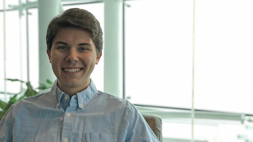 Asher Mazaika in the Babbio Center, with the New York skyline in the background.
