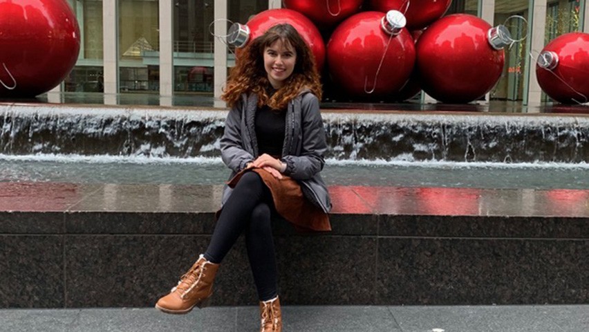 Eden Luvishis seated in an outdoor courtyard.