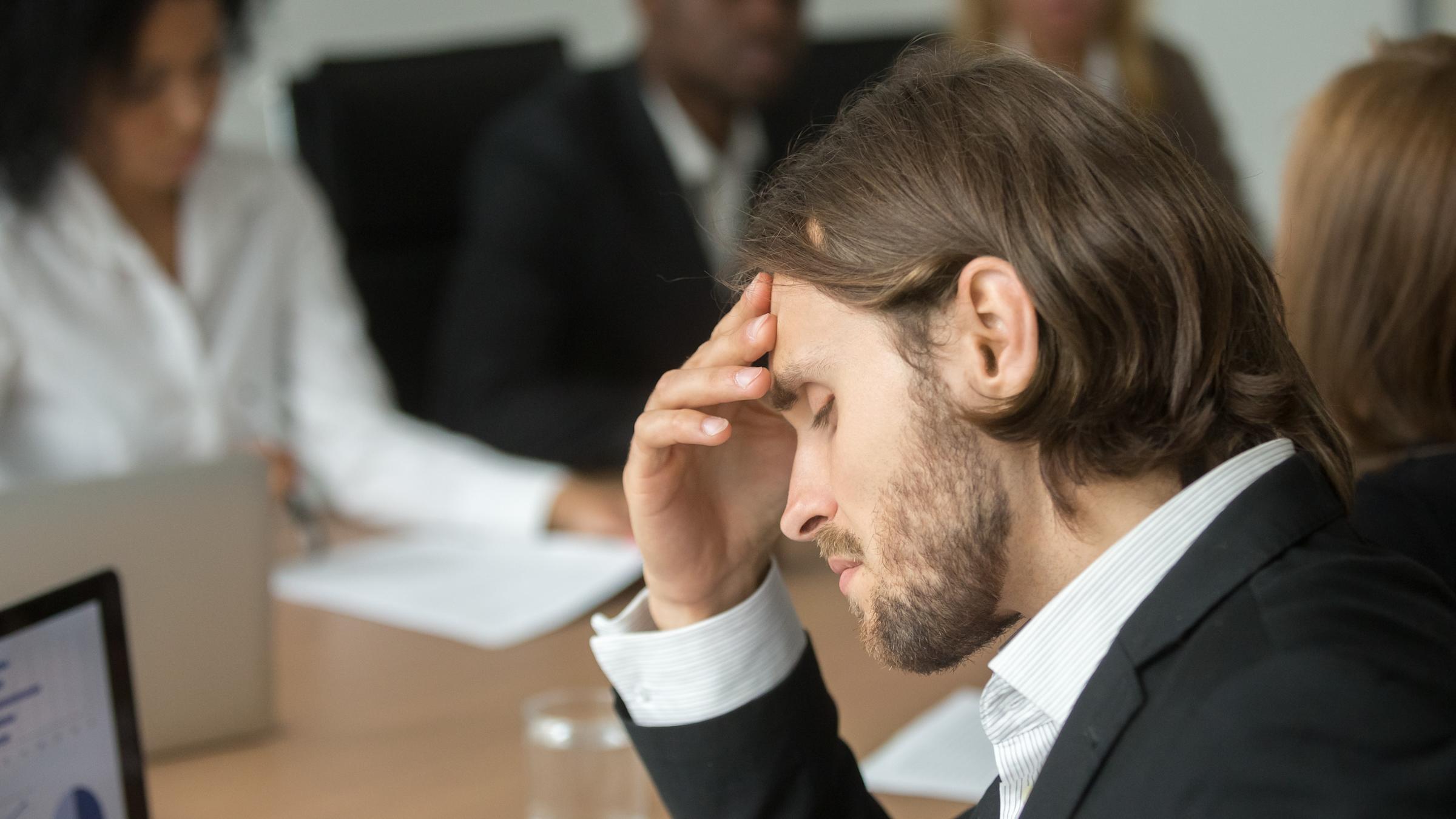 A man seated in front of a laptop