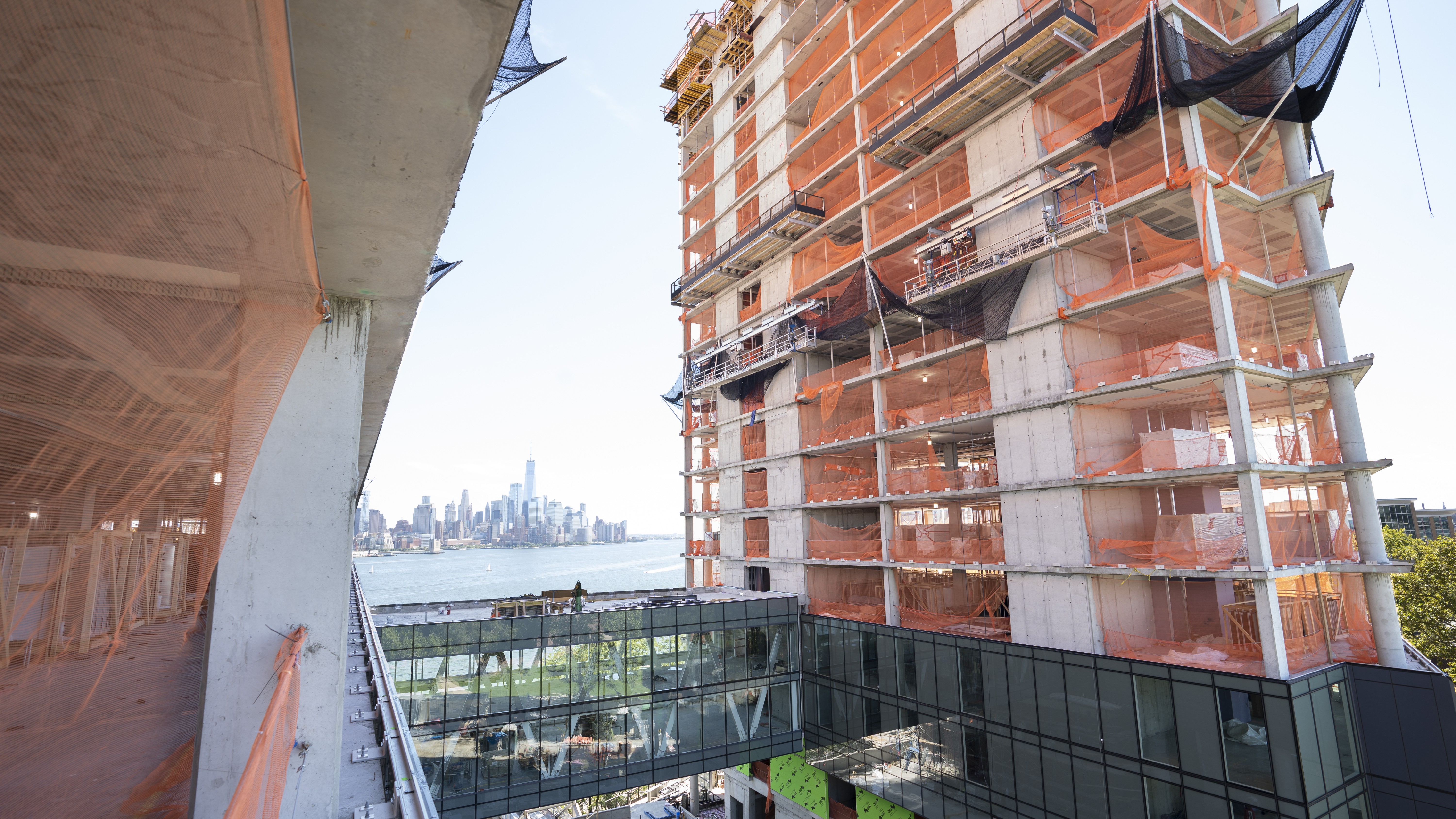 A construction management student wearing site-gear standing on a piece of equipment.