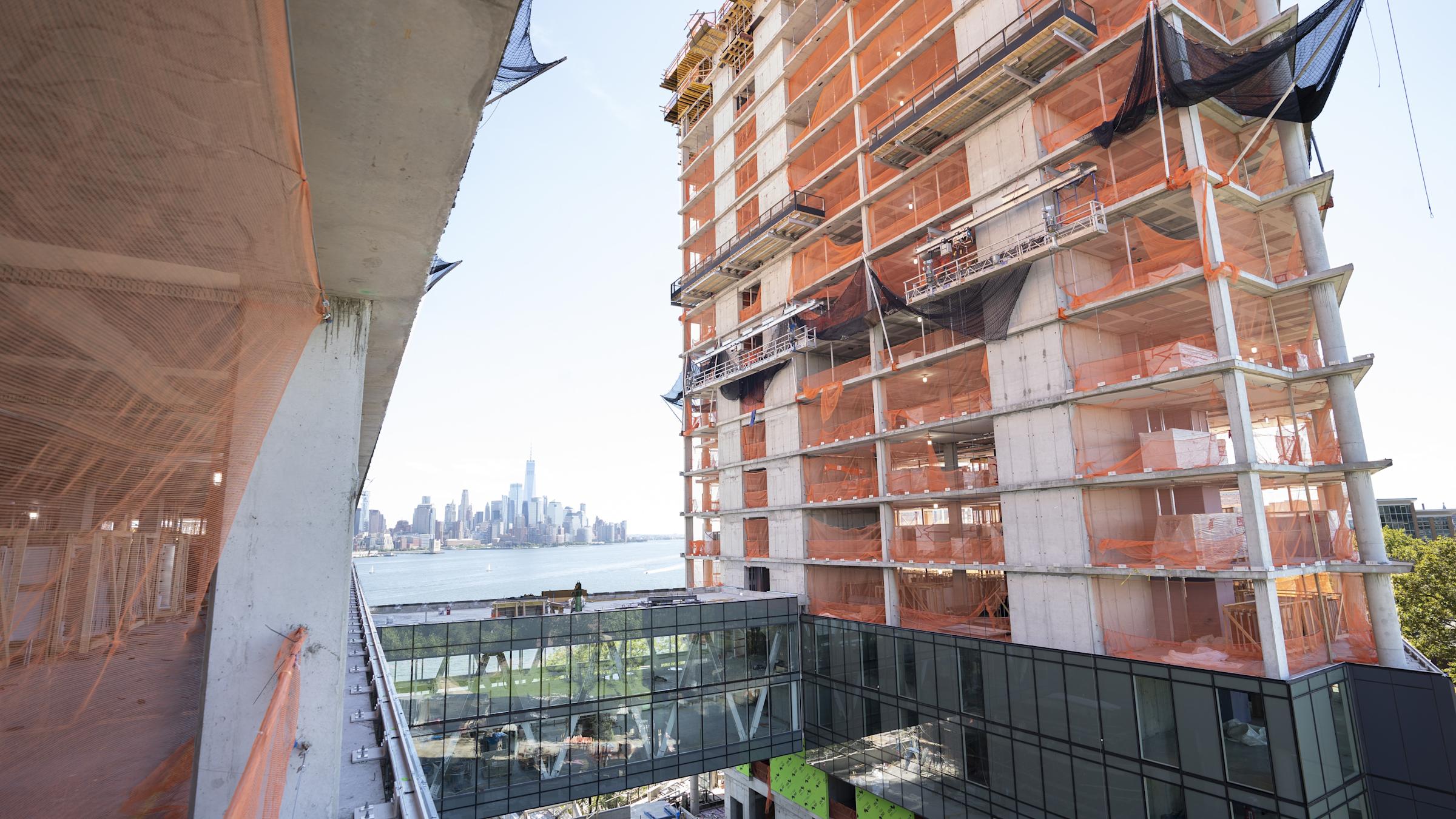 A construction management student wearing site-gear standing on a piece of equipment.