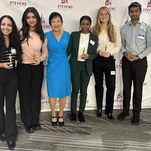 Students in the Department of Biomedical Engineering pose in front of a Stevens Institute of Technology backdrop with Jennifer Kang-Mieler, who is the department chair of the Department of Biomedical Engineering.