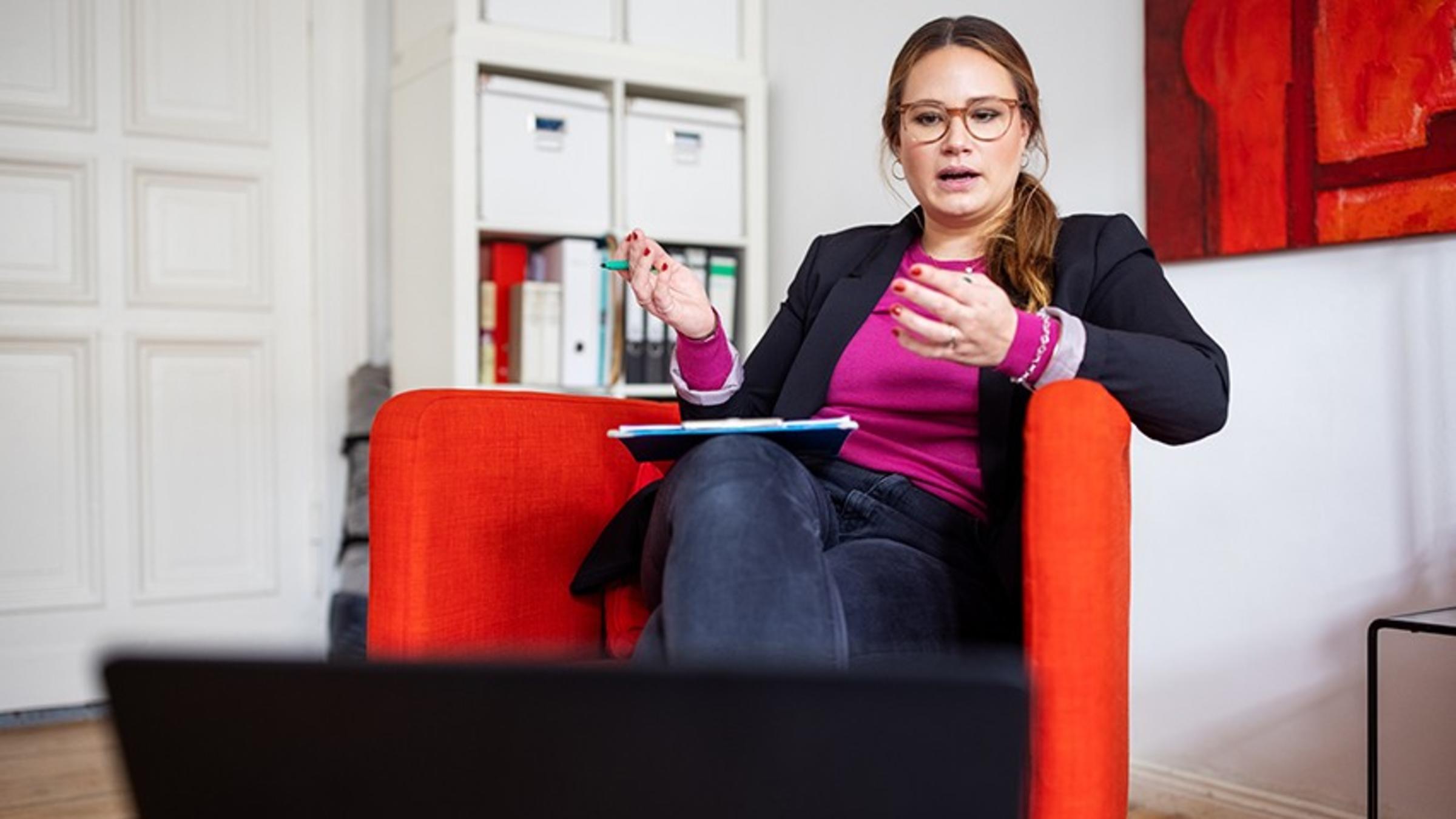 A female therapist speaks to a patient via computer from her home.