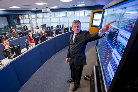 Dragos Bozdog, in a blue suit, teaching in the Hanlon Lab.