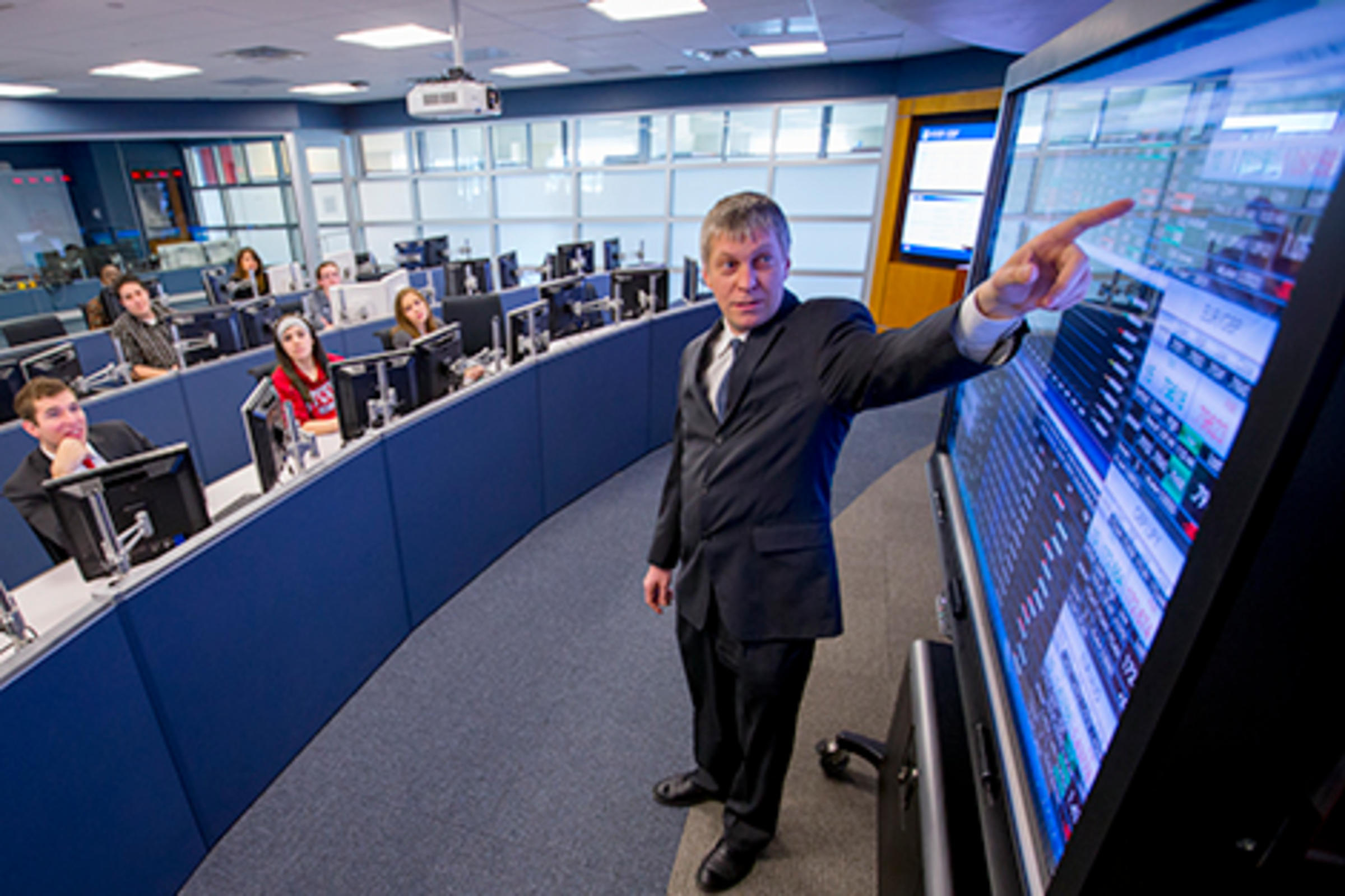 Dragos Bozdog, in a blue suit, teaching in the Hanlon Lab.
