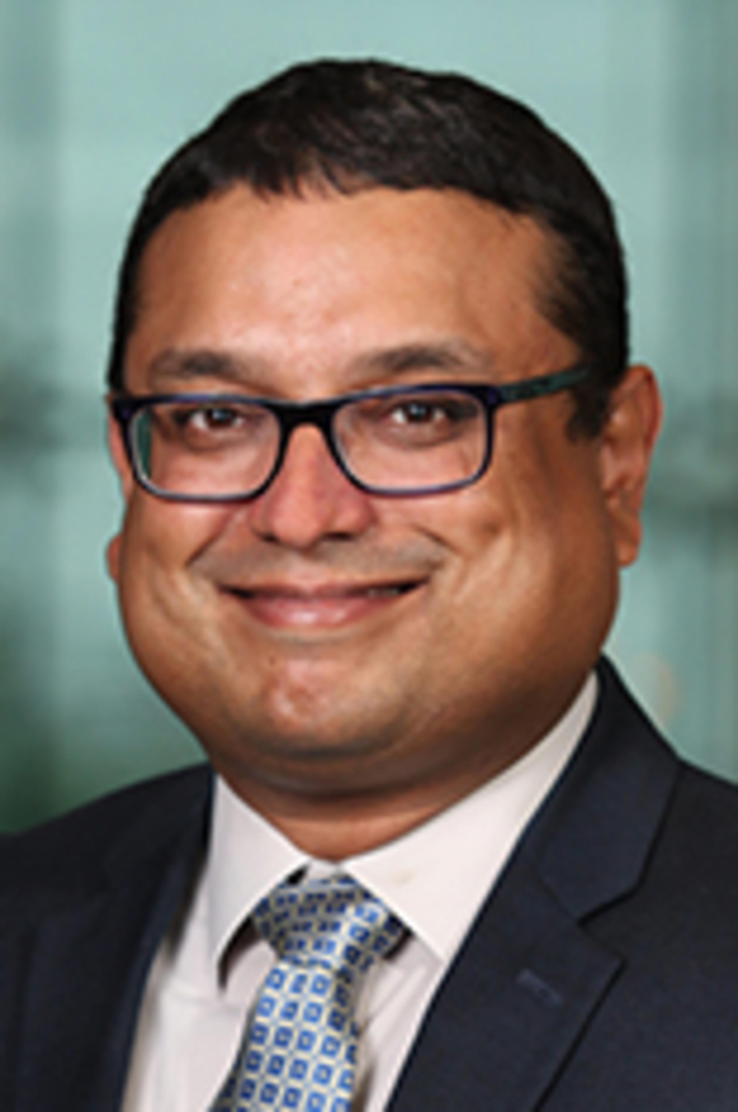 Headshot of Dr. Gaurav Sabnis with the New York City skyline visible in the background.