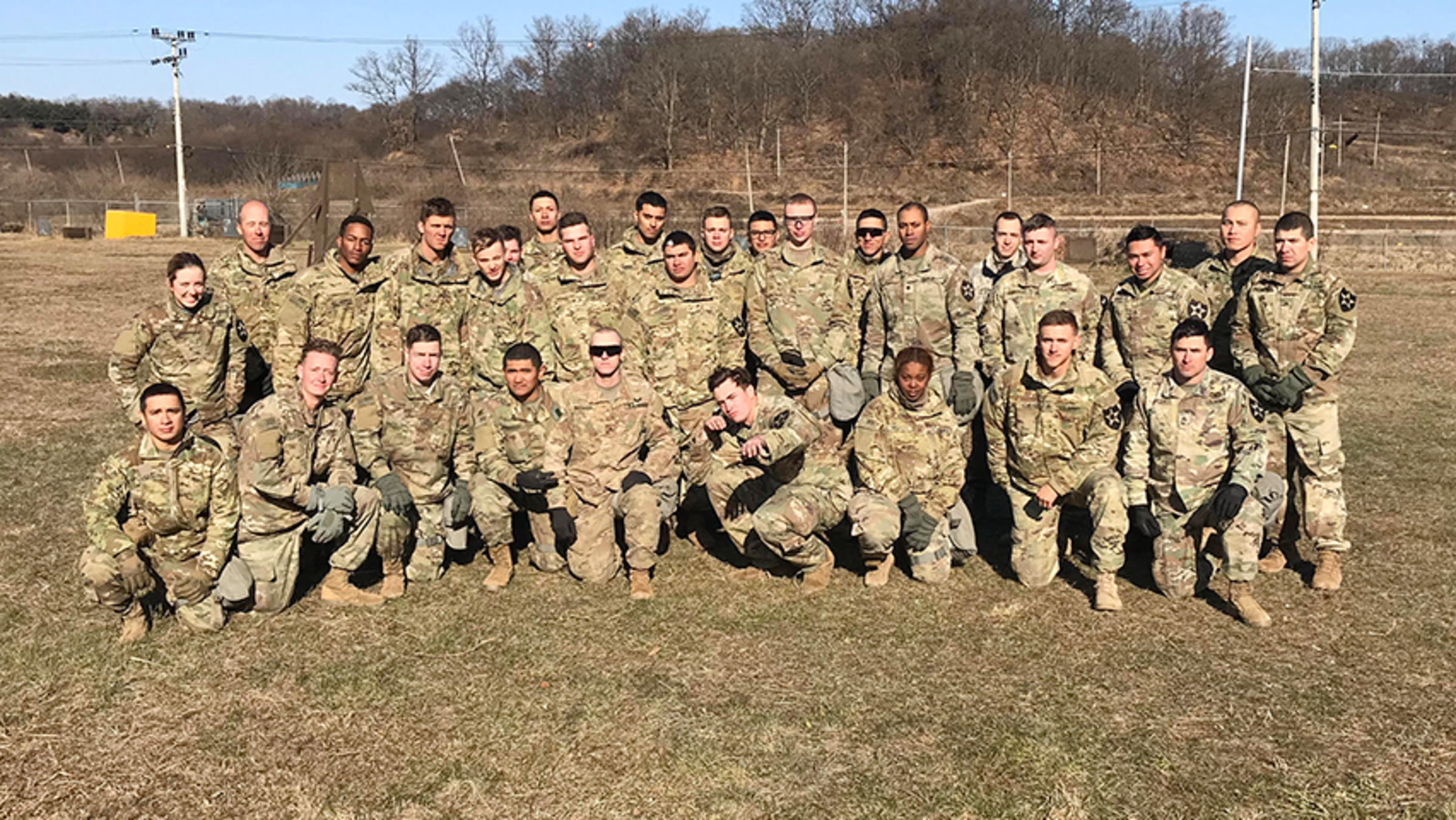 Photo of a group of soldiers posing for a photo in a field.