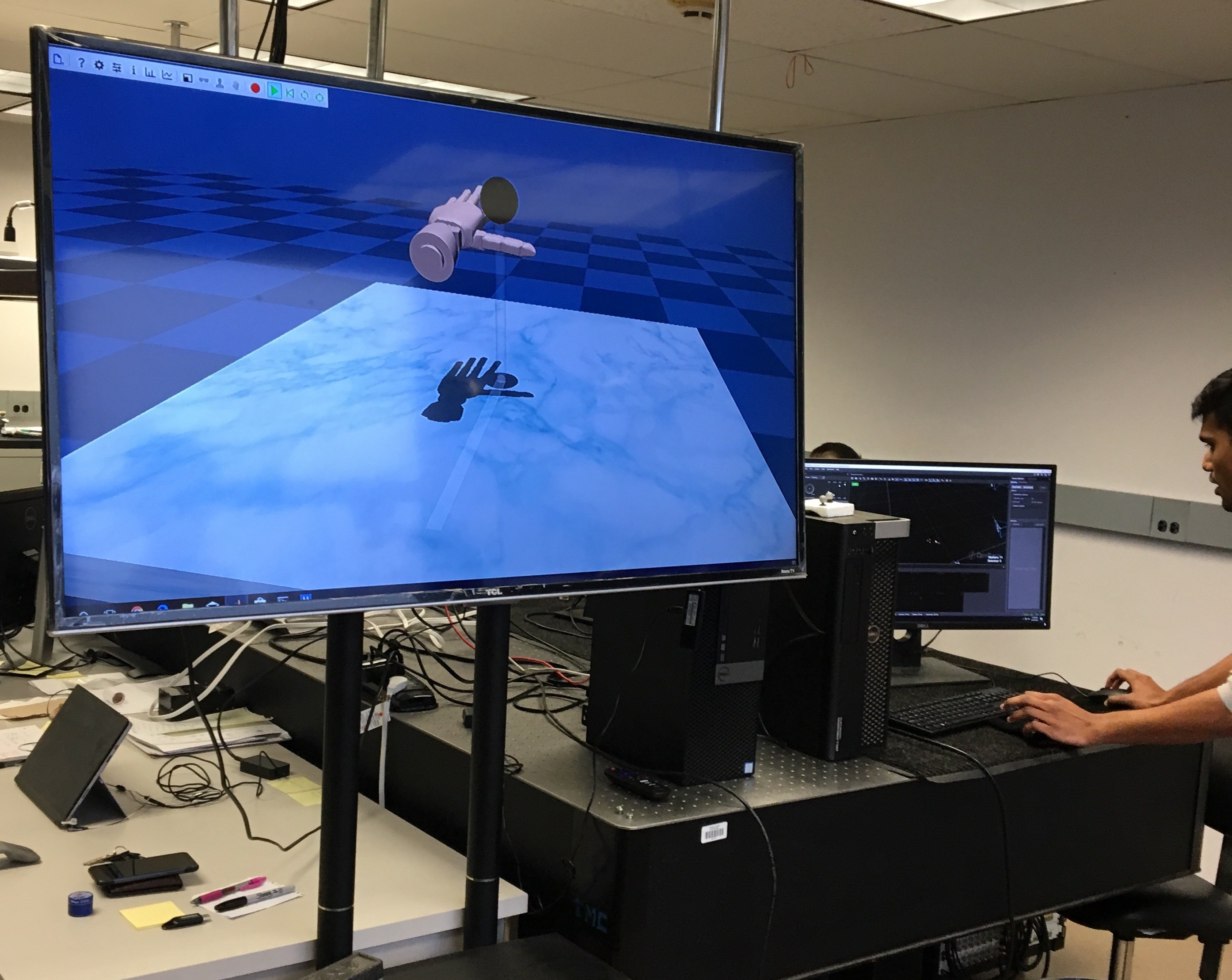Ph.D. student with computer screen depicting virtual hand
