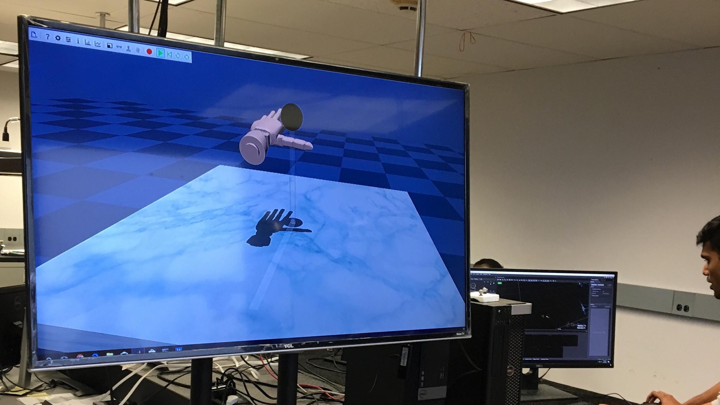 Ph.D. student with computer screen depicting virtual hand