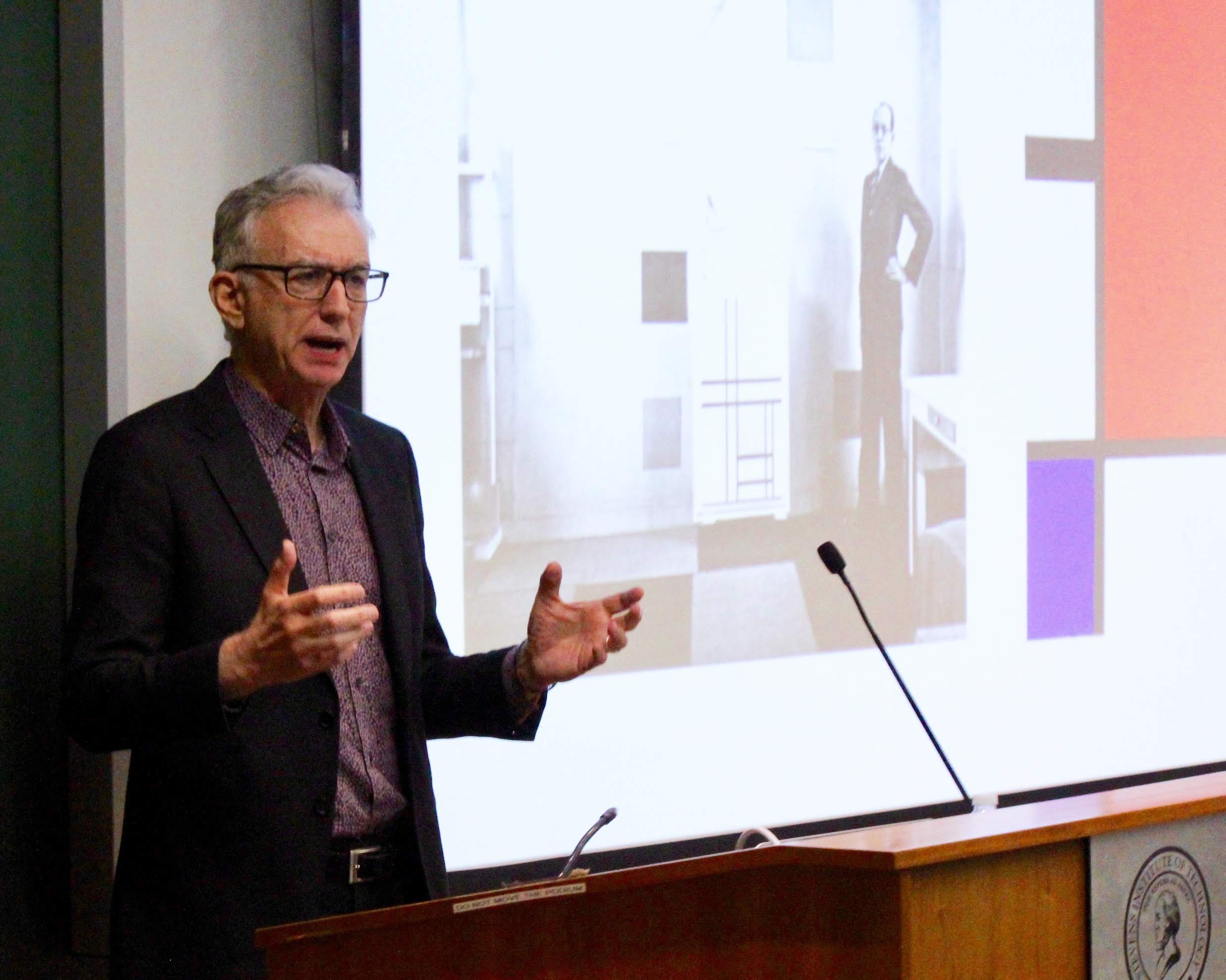 Jed Perl at the podium in Babbio Center standing in front of projected image of Alexander Calder