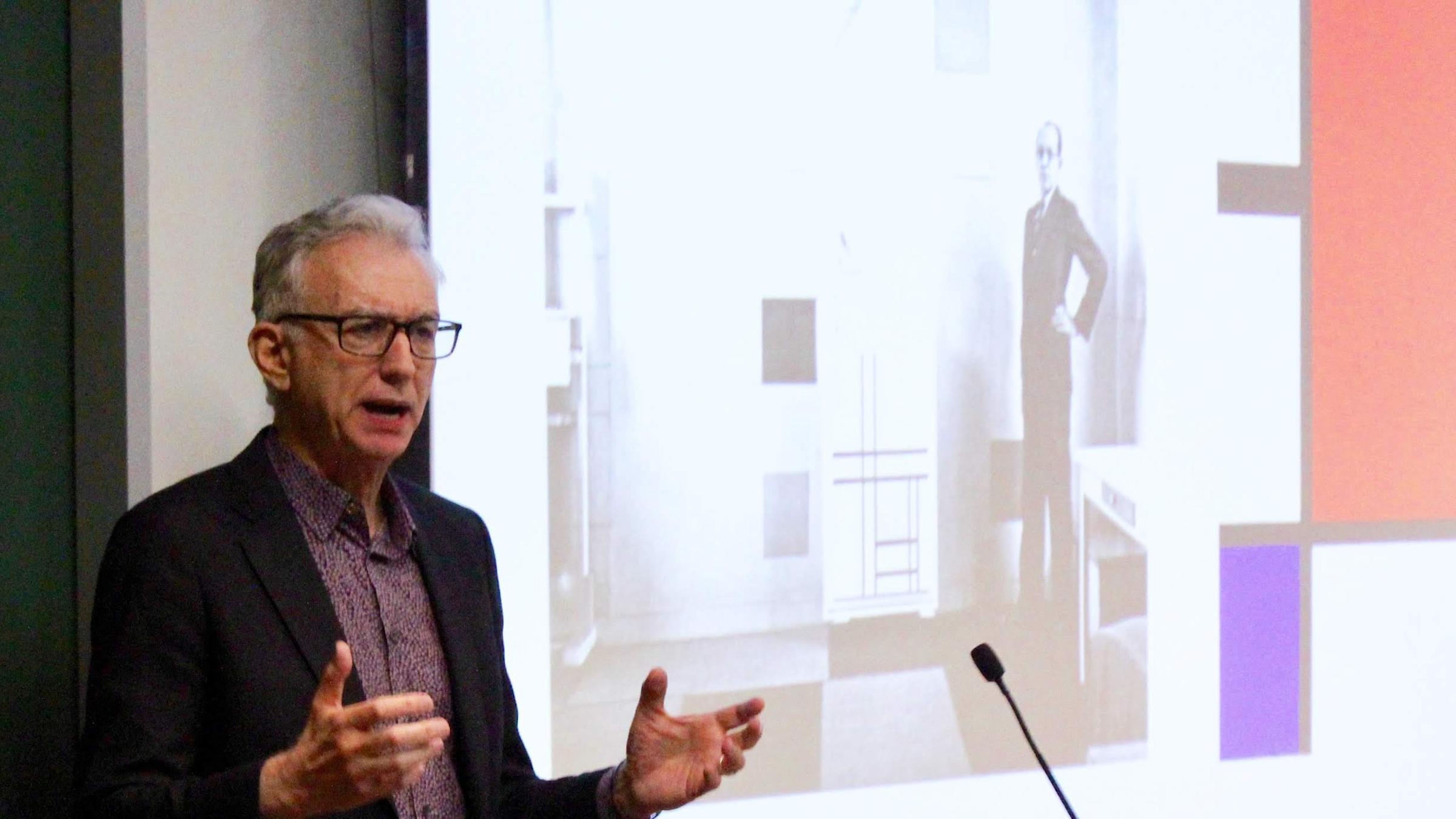 Jed Perl at the podium in Babbio Center standing in front of projected image of Alexander Calder