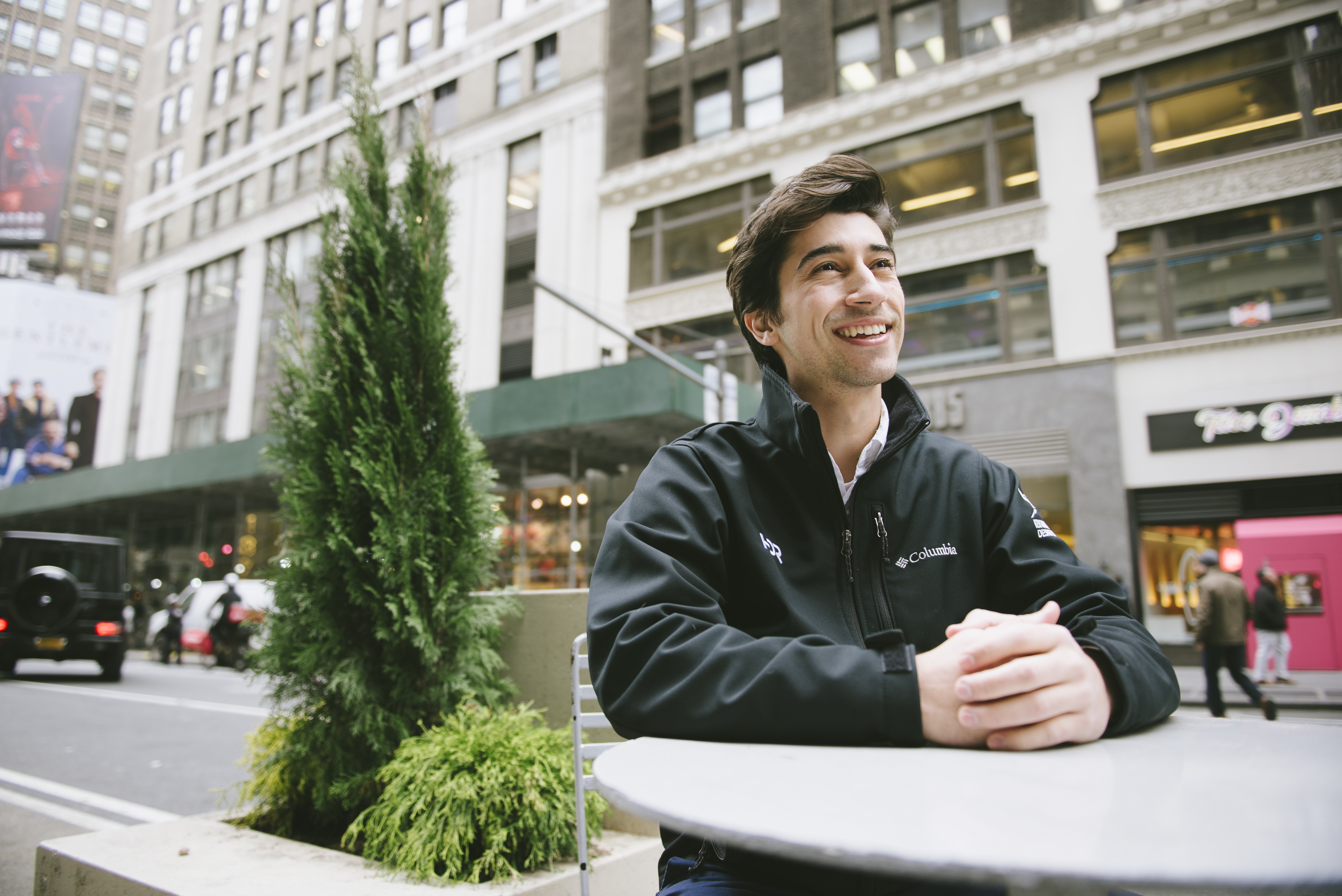 Photo of Ryan Bertani sitting at table in Times Square, New York City