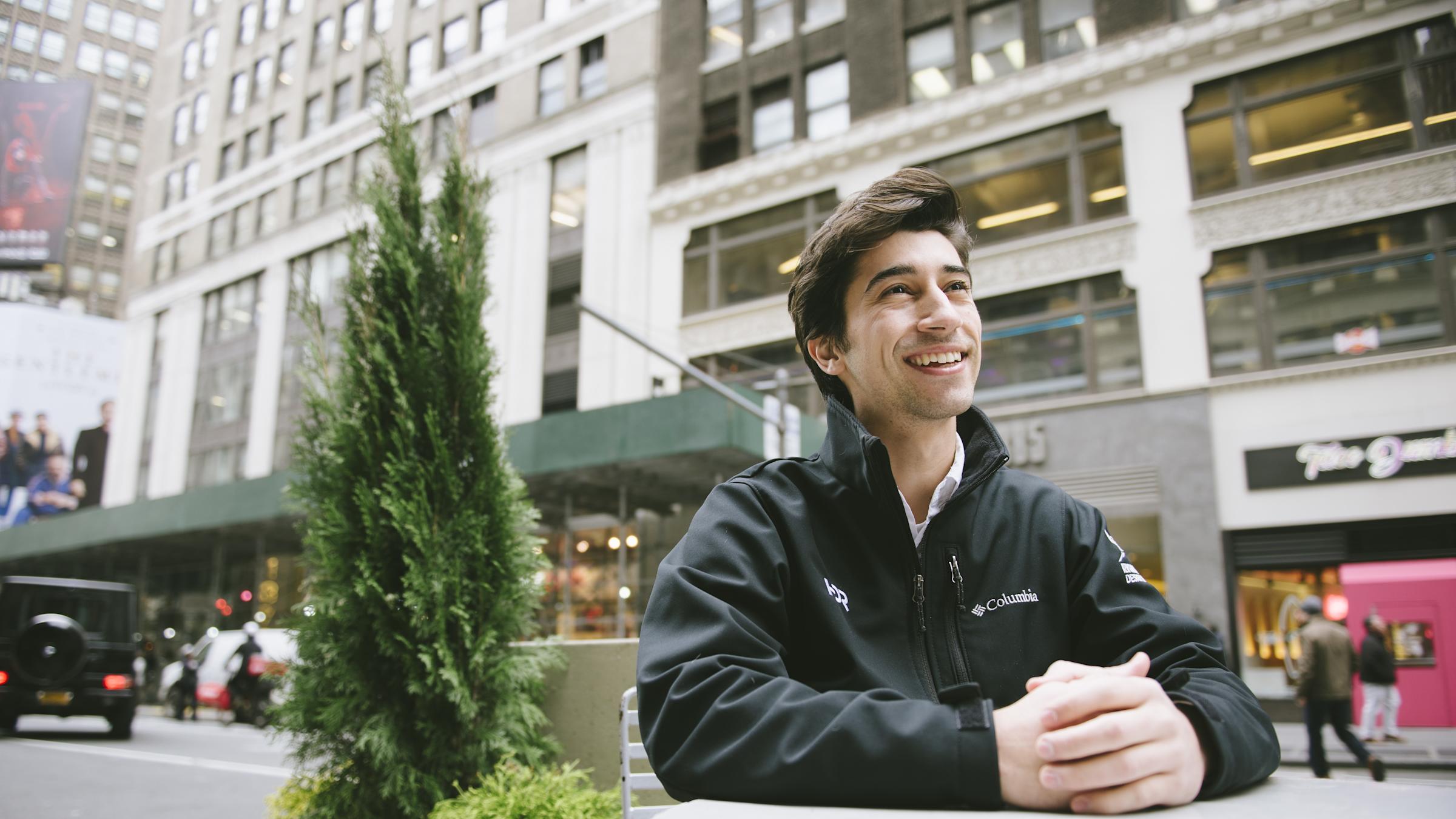 Photo of Ryan Bertani sitting at table in Times Square, New York City