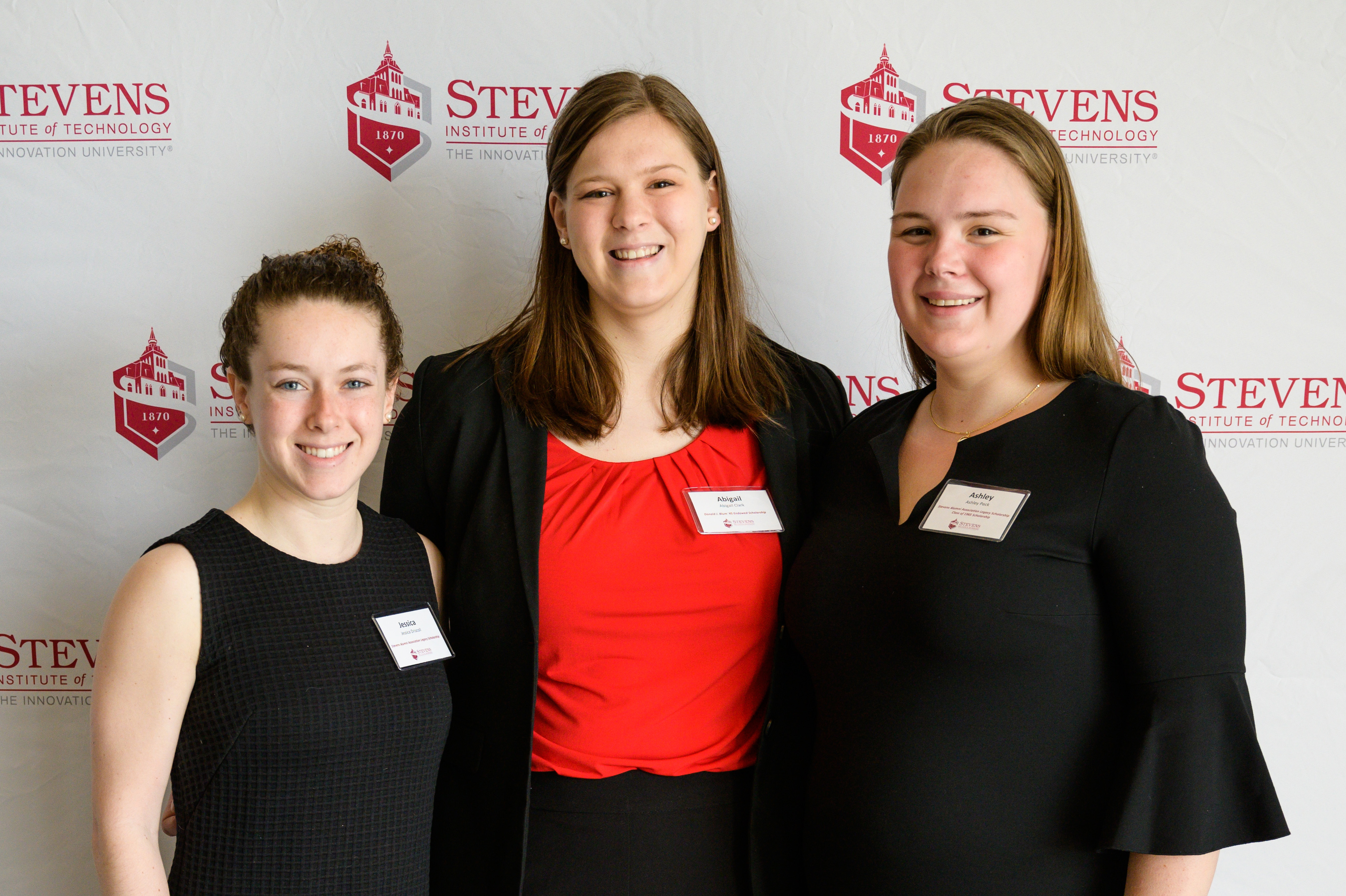 Three female students smile at scholarship event