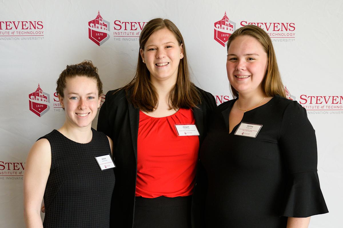 Three female students smile at scholarship event