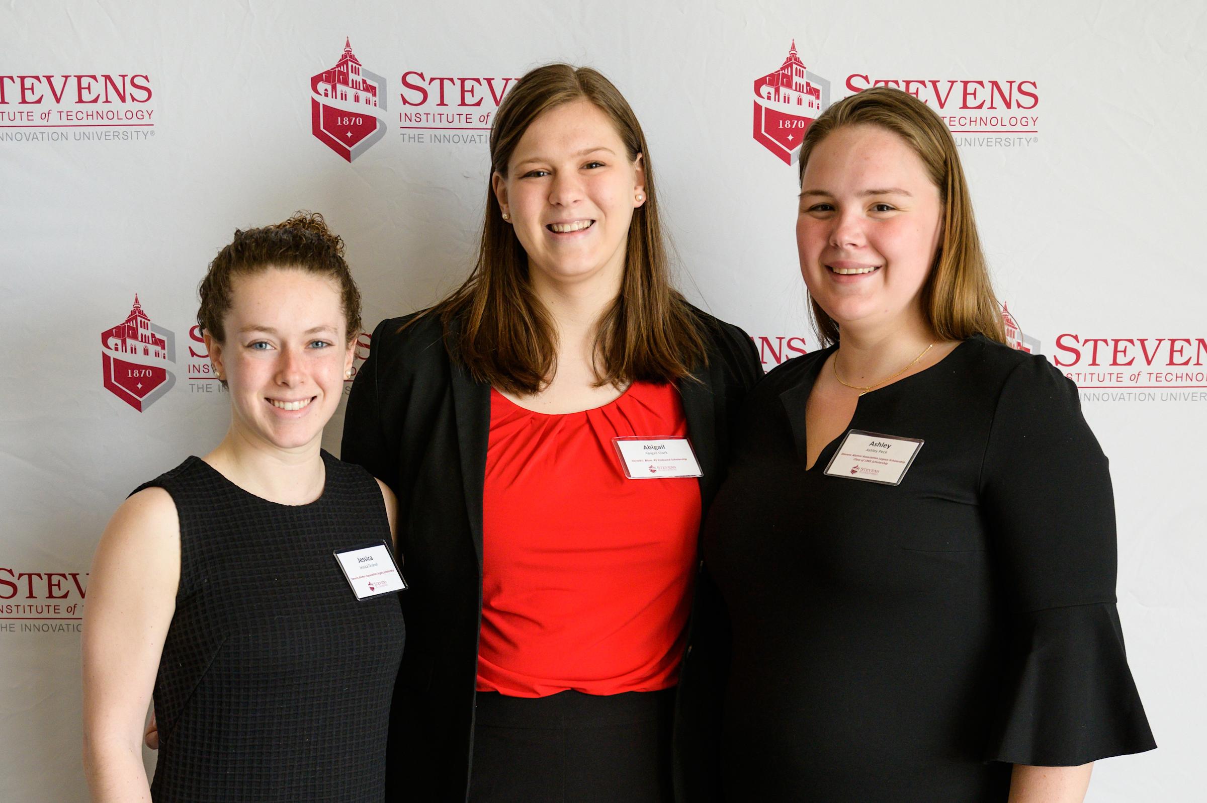 Three female students smile at scholarship event