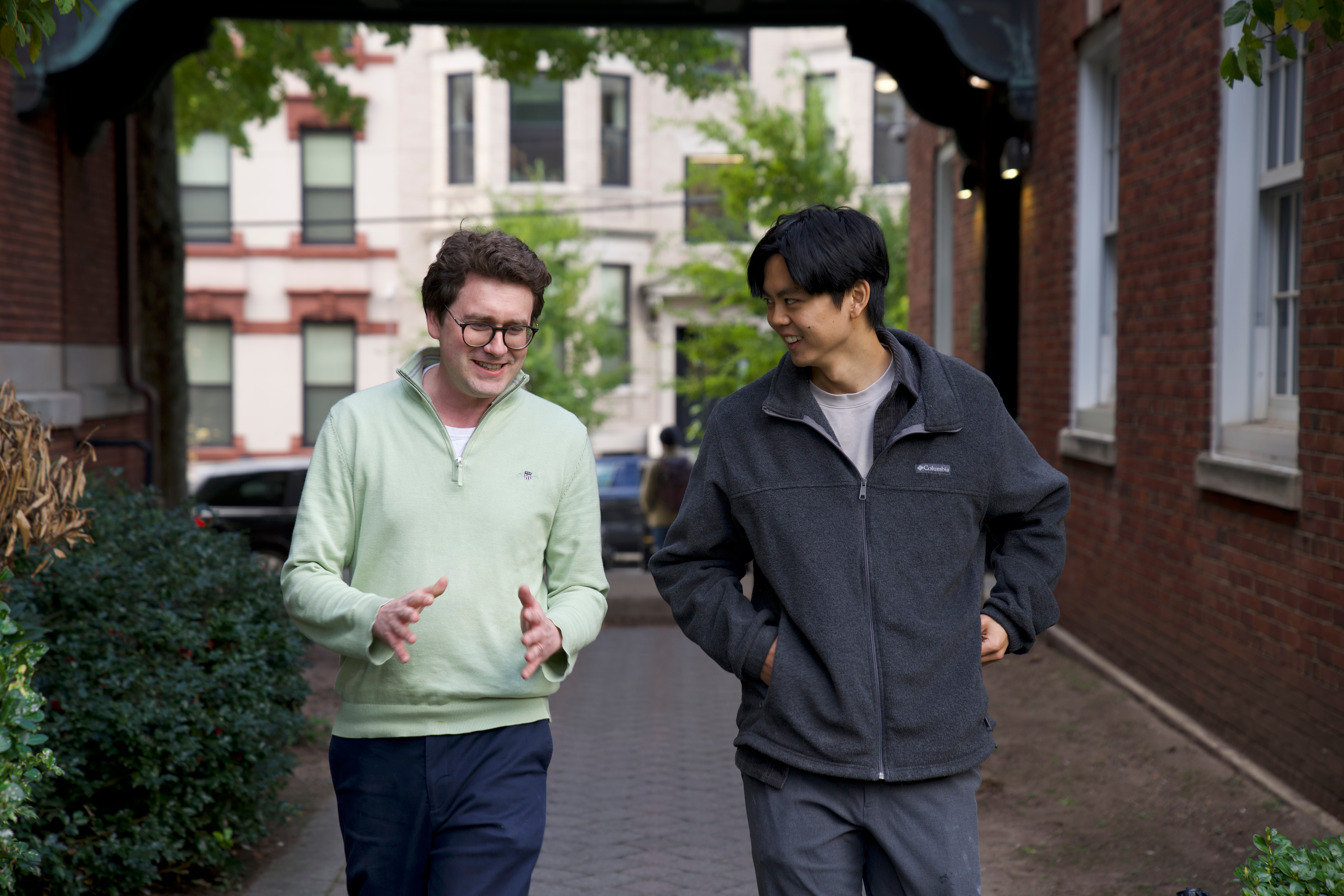 Two males - Professor Igor and student walking on campus having a conversation
