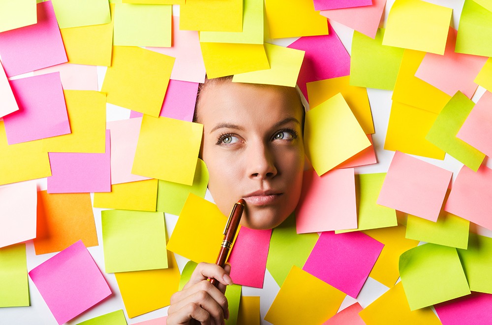 A woman's head surrounded by pink, green, yellow and purple post-it notes