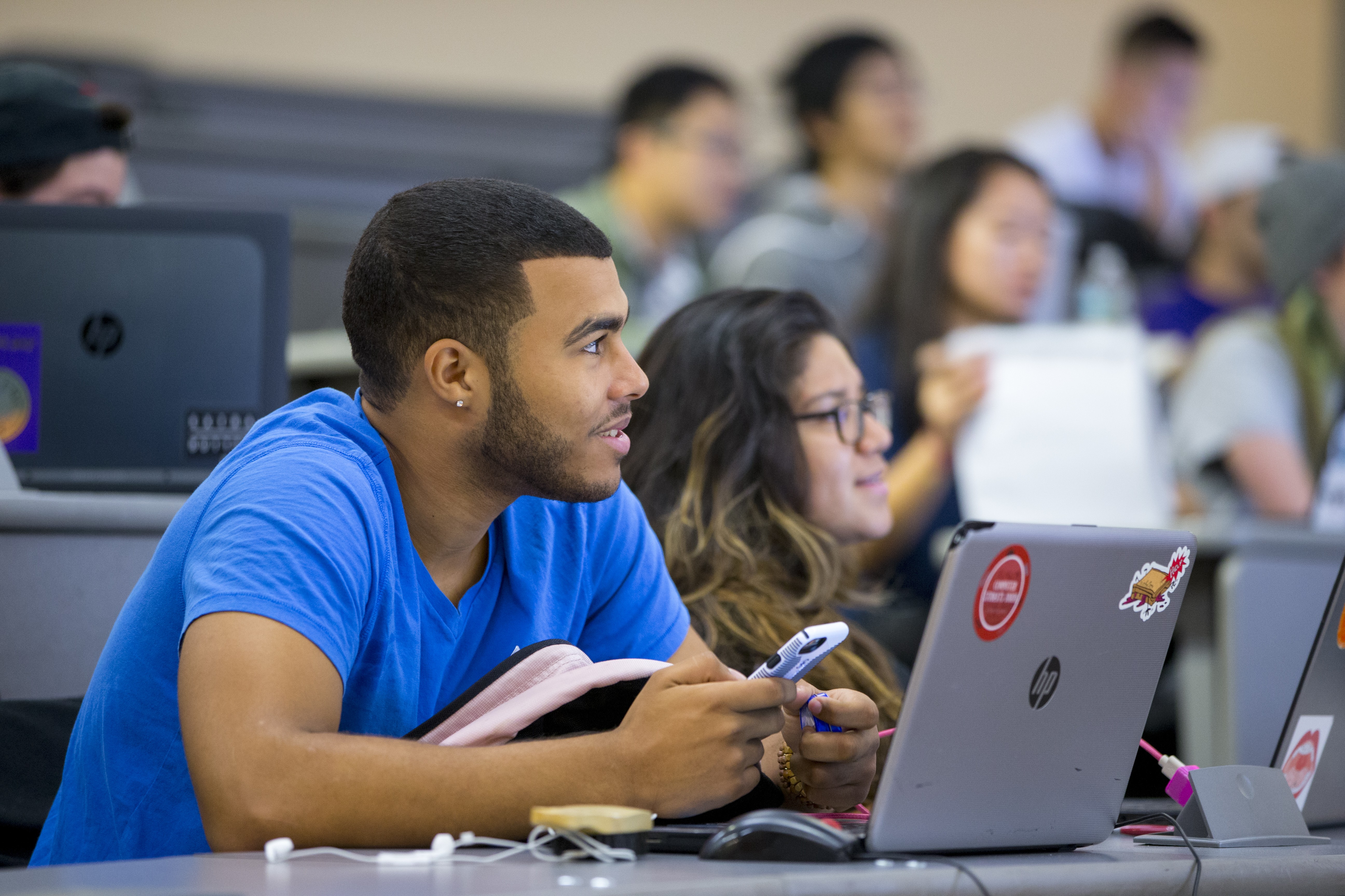 Students smiling in classroom listening to lecture