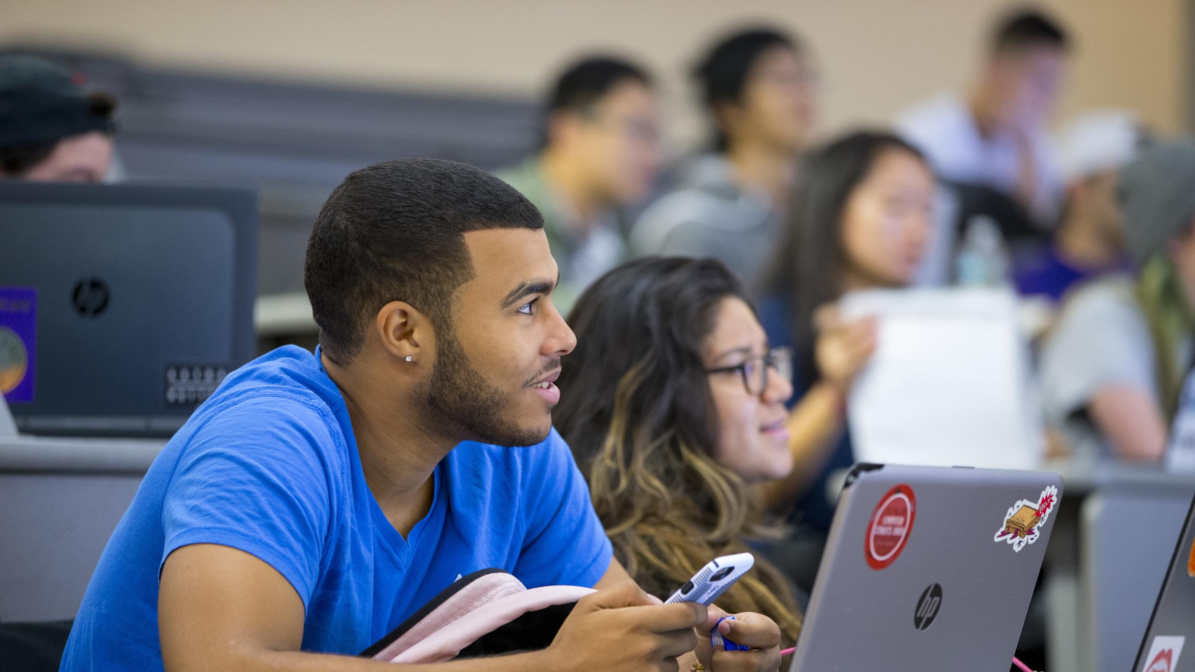 Students smiling in classroom listening to lecture