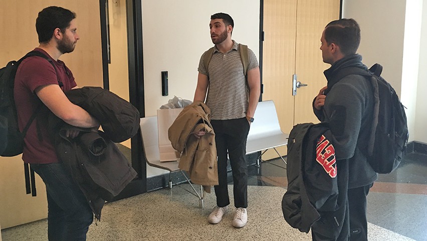 Marshall Singer answers questions from a group of students surrounding him. 