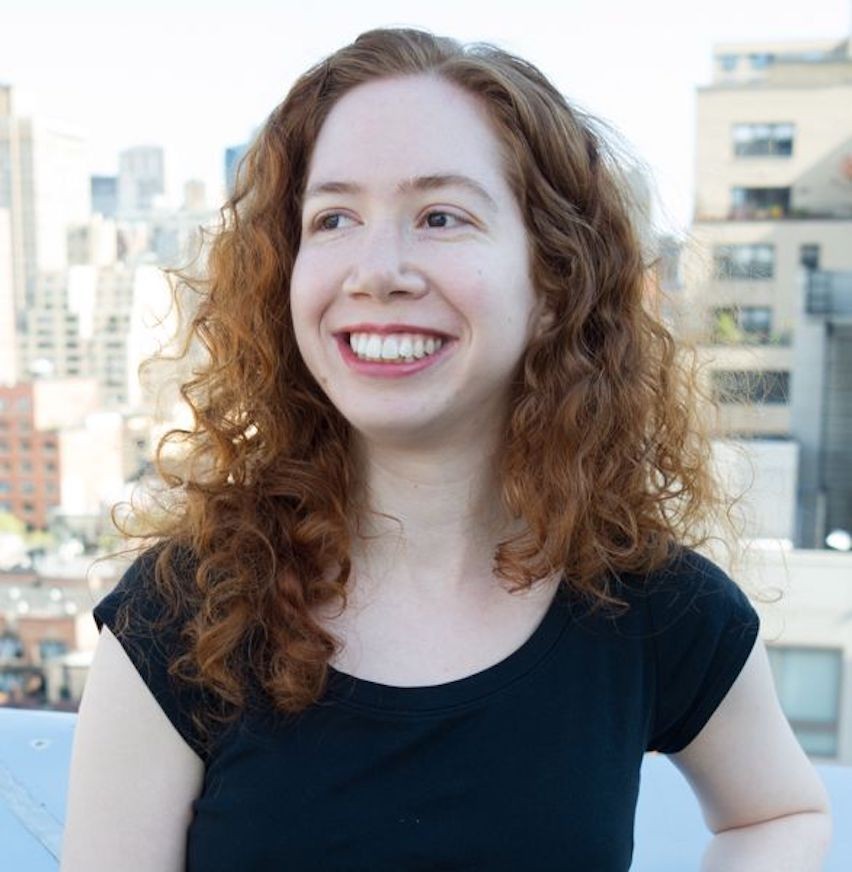 Picture of Samantha Kleinberg in black short-sleeved shirt. She is white with red hair and she is smiling. 