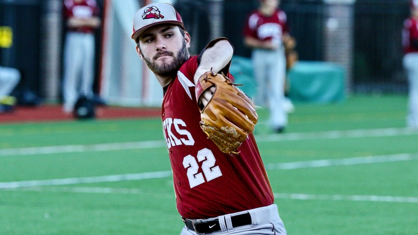 Charlie Ruegger in a red Ducks jersey and cap throwing out a pitch.