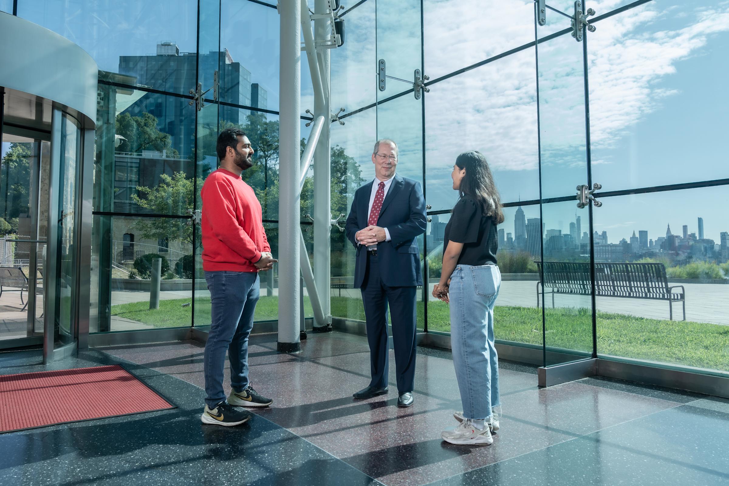 GJ de Vreede talks with two students in the lobby of the Babbio Center.