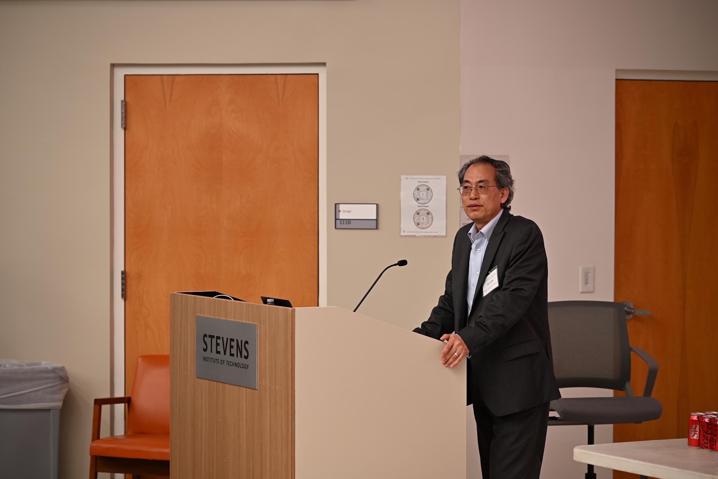 A photo of Min Song standing at a podium.