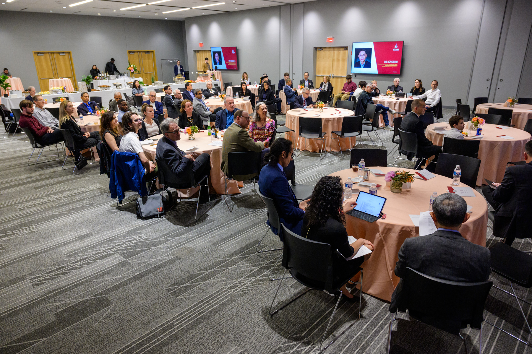 A wide shot of the room with people looking at the stage. 