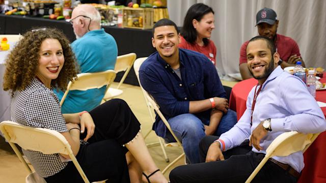 Young alumni smile at Alumni Weekend event
