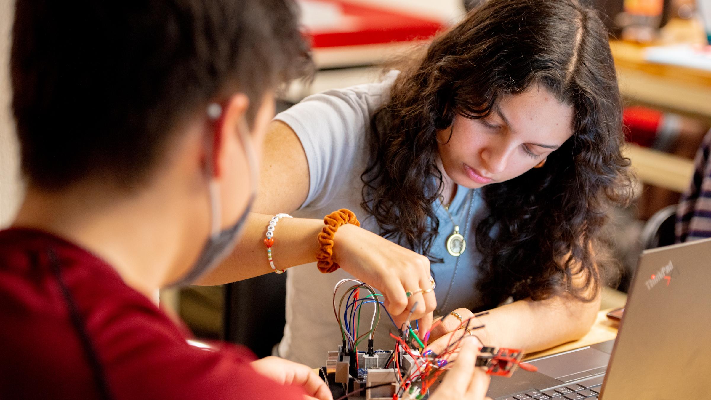 Two students working on a small robot