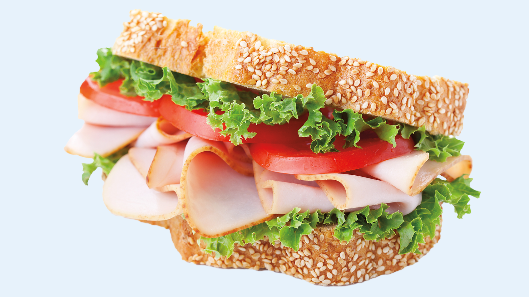 A large, sliced turkey sandwich with lettuce and tomato.