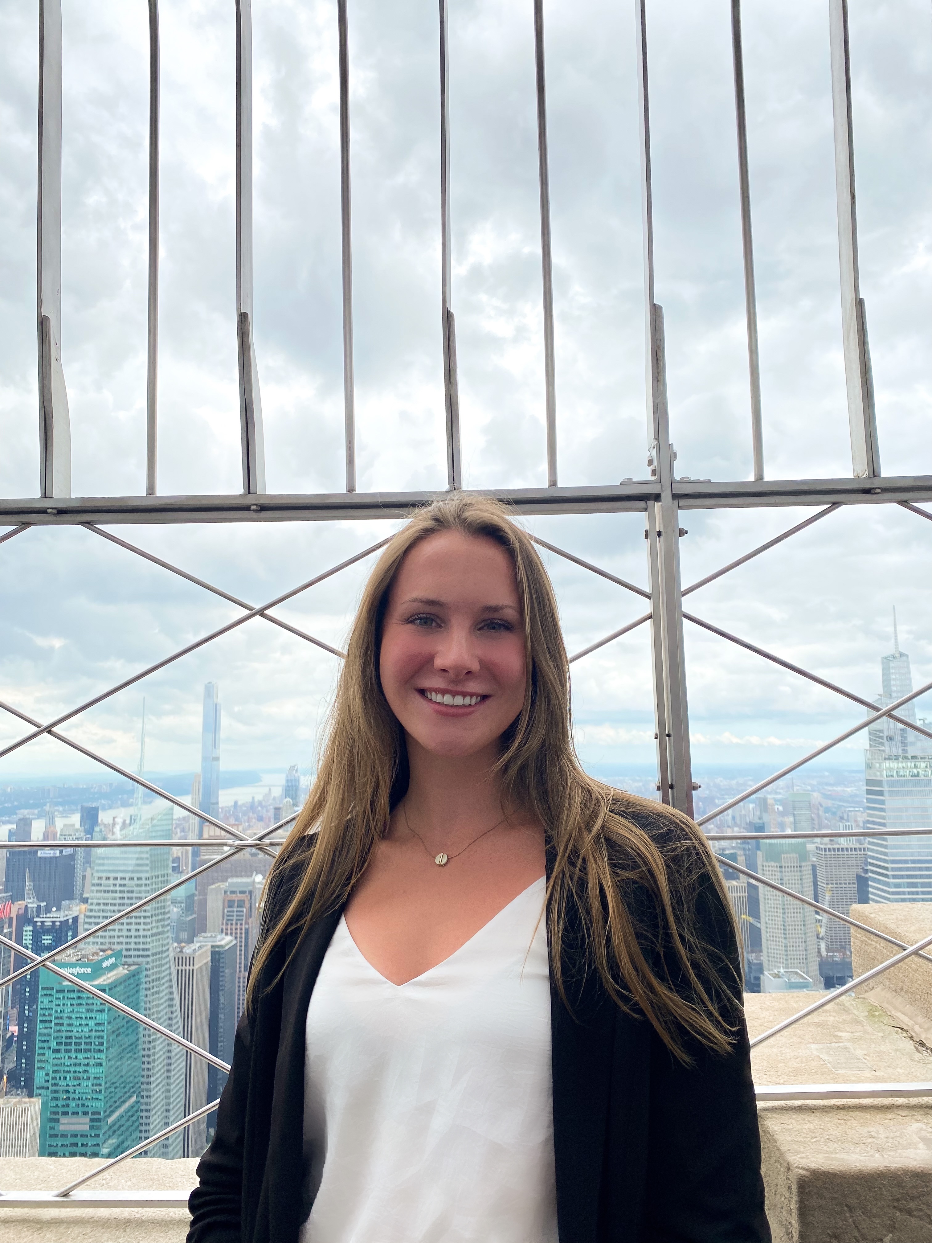 A casual photo of Megan Dion with the NYC skyline behind her