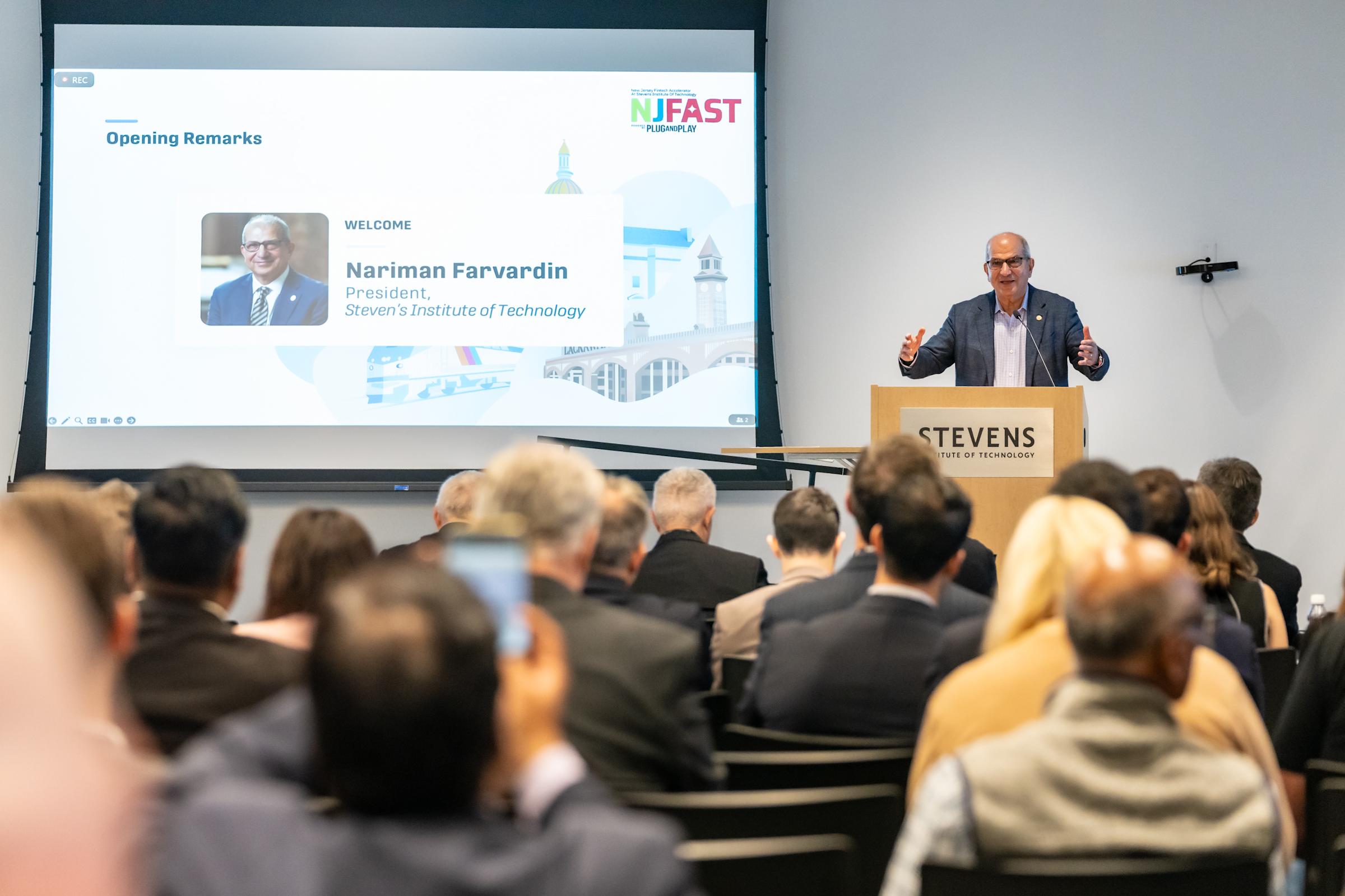 Nariman Farvardin speaks to the crowd from behind a podium. 