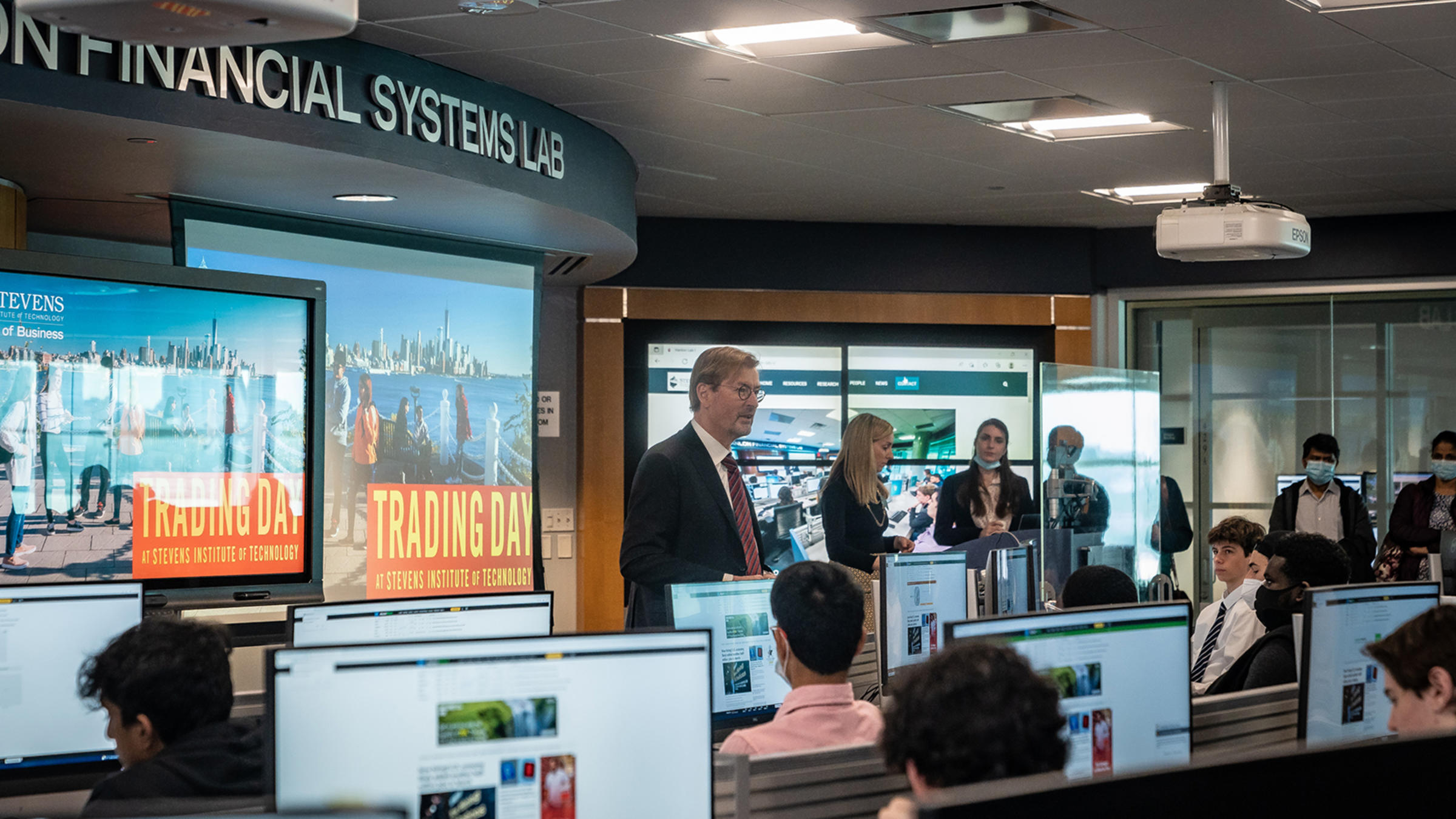 George Calhoun and Lindsay Hartelius in front of students during Trading Day