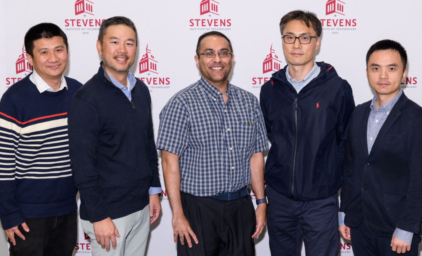 Yu Gan, Robert Chang, Ravi Nataraj, Jinho Kim and Pin-Kuang Lai standing side-by-side in front of a Stevens-branded backdrop. 