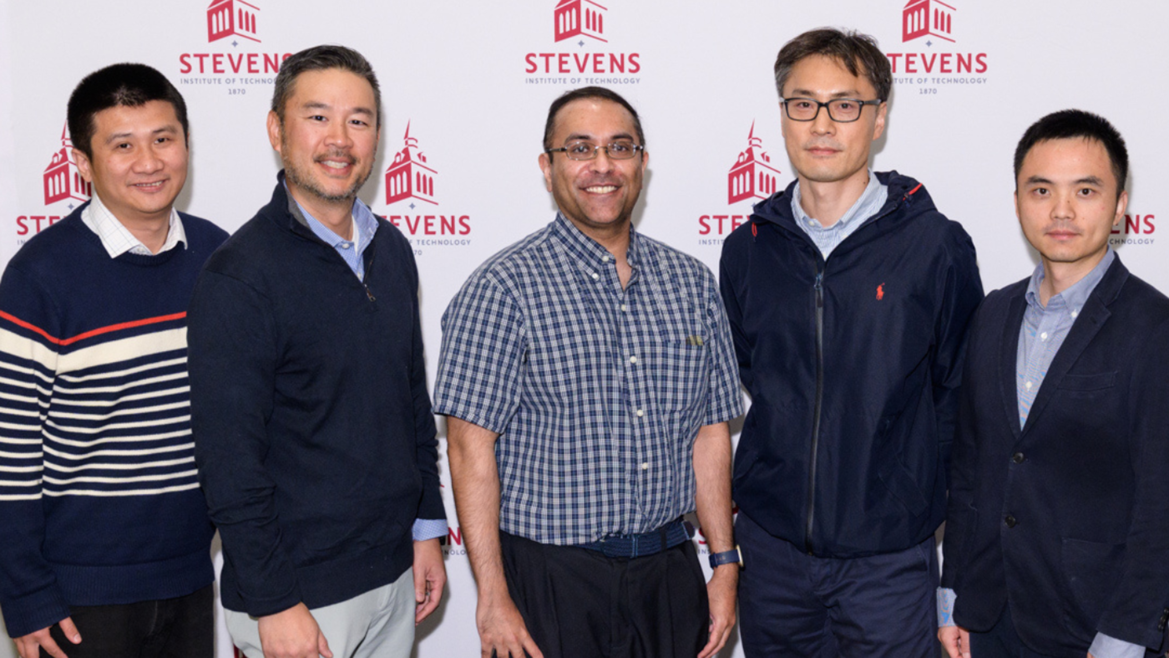 Yu Gan, Robert Chang, Ravi Nataraj, Jinho Kim and Pin-Kuang Lai standing side-by-side in front of a Stevens-branded backdrop.
