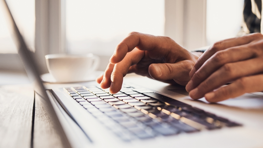 Hands typing on laptop.