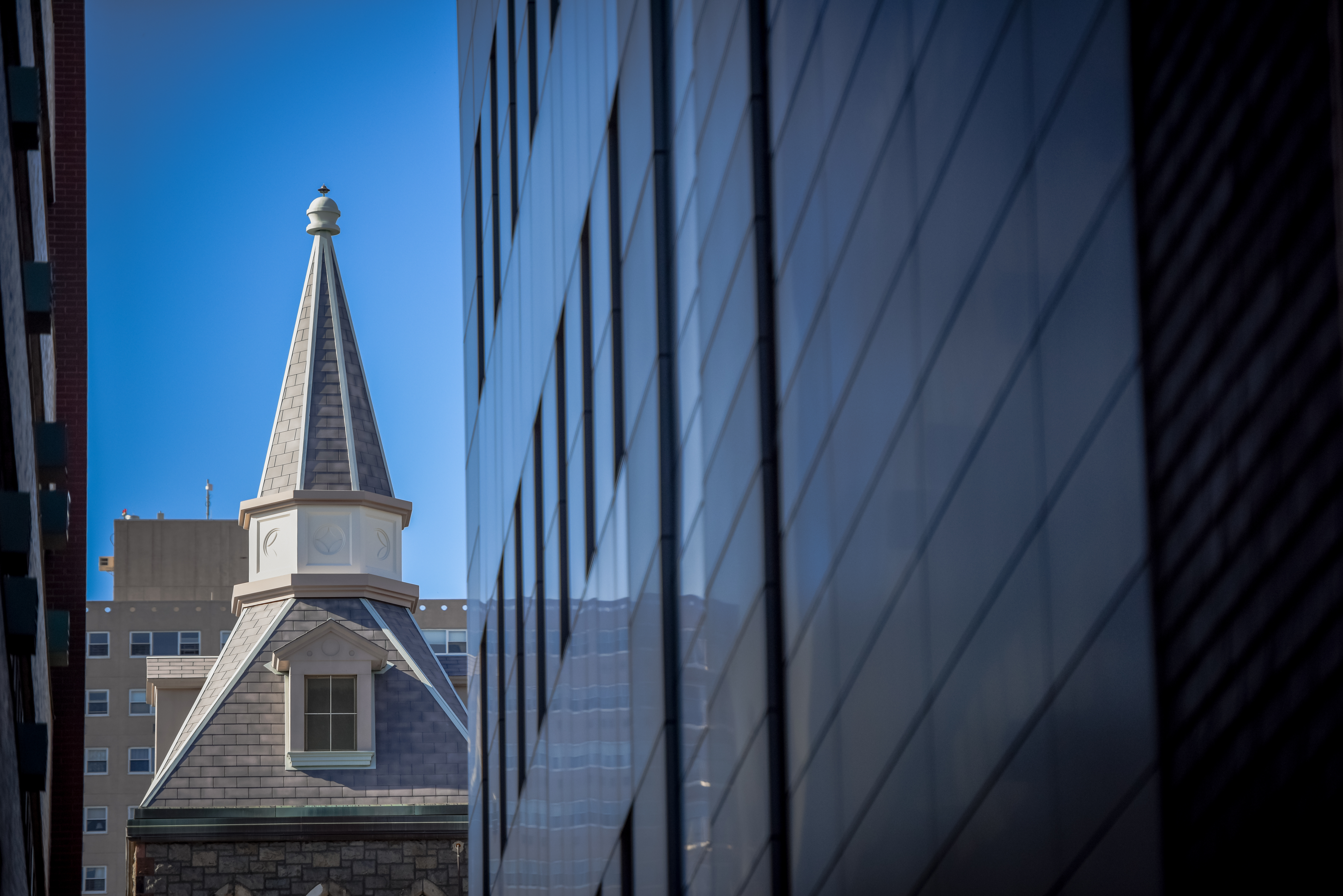 Spire of the EAS building seen from afar between two buildings