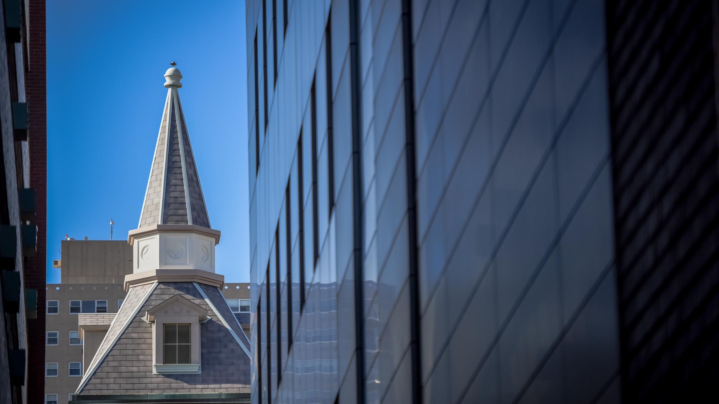 Spire of the EAS building seen from afar between two buildings