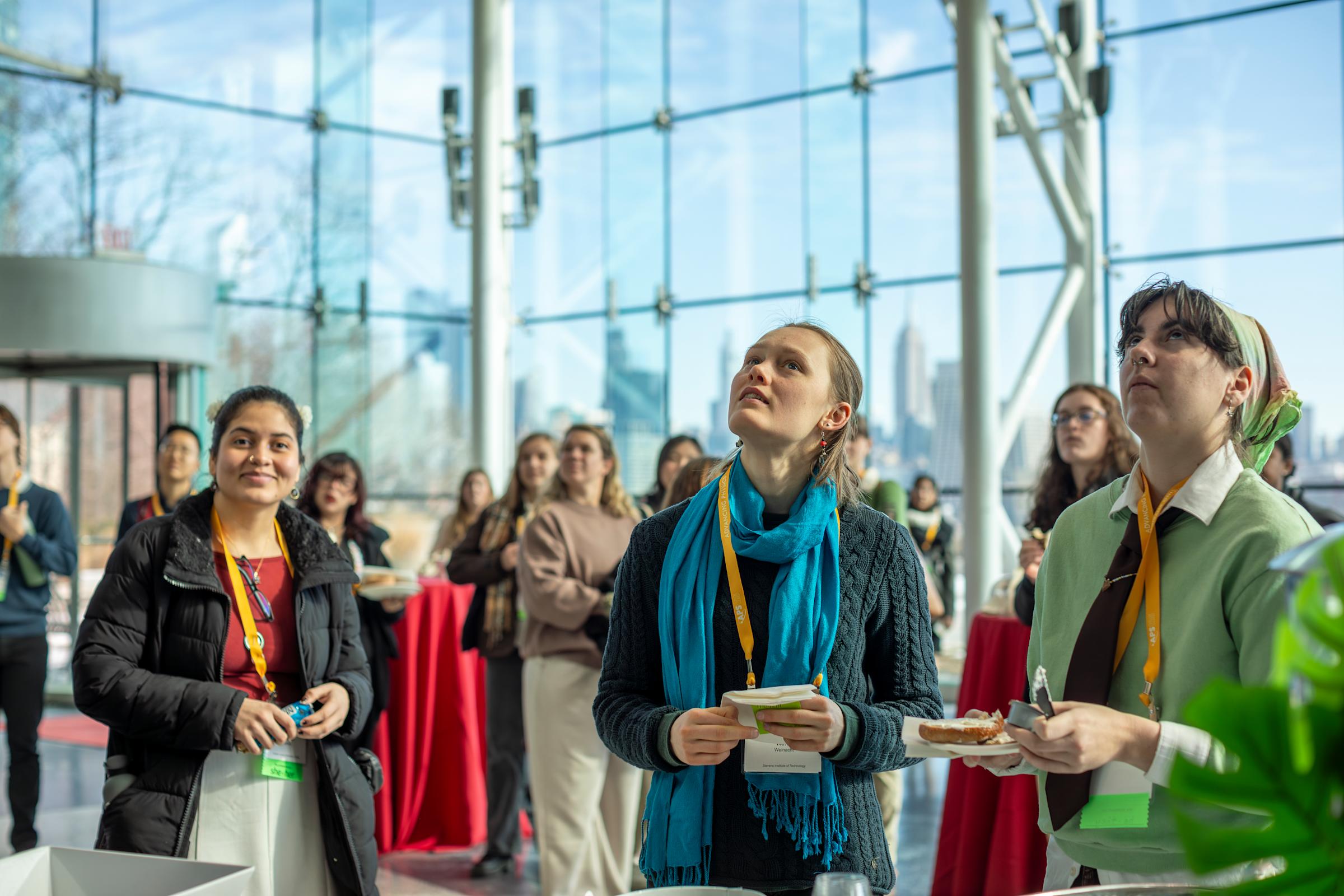 CUWIP conference attendees looking upward in the atrium of the Babbio Center.