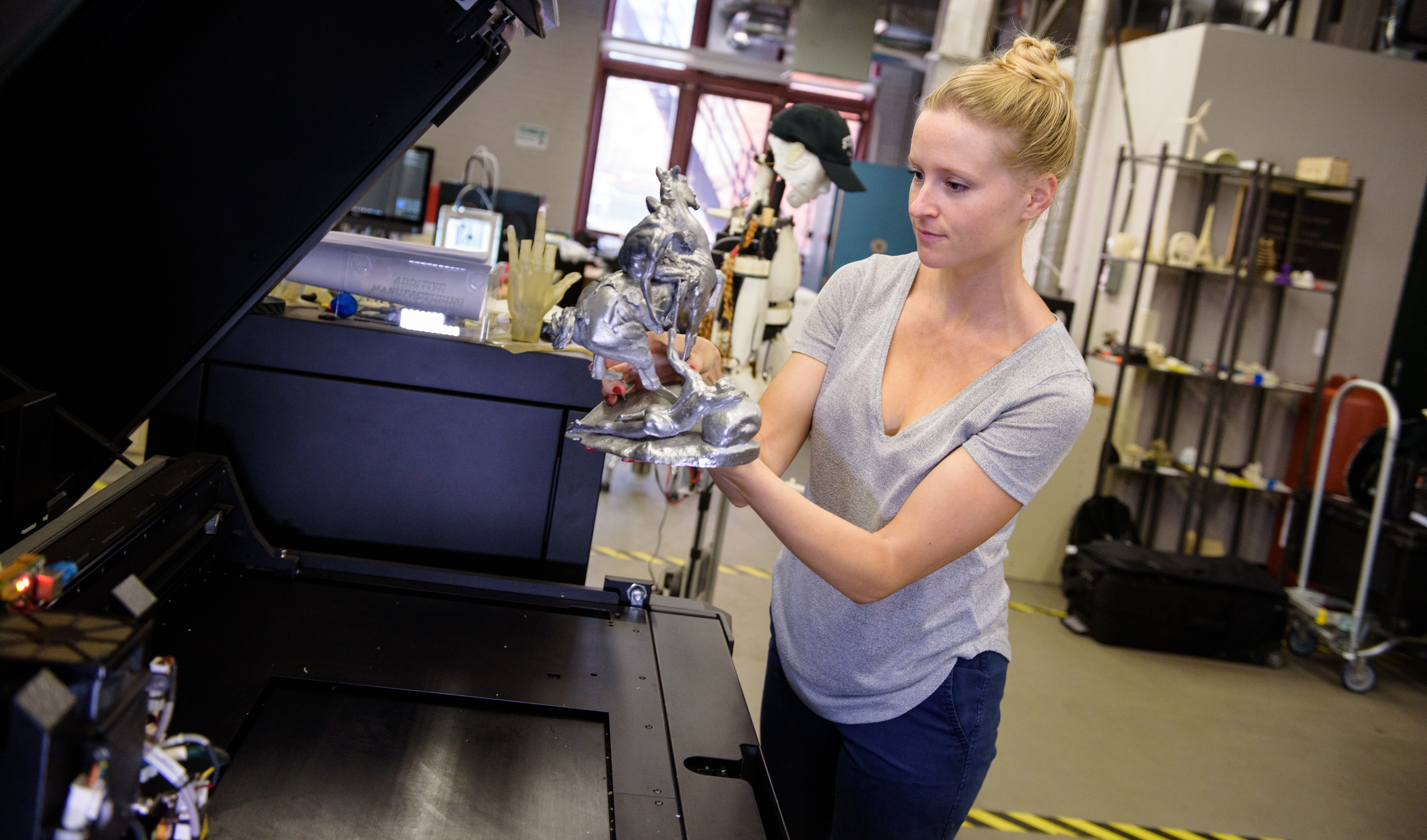Female student holding a metallic statue