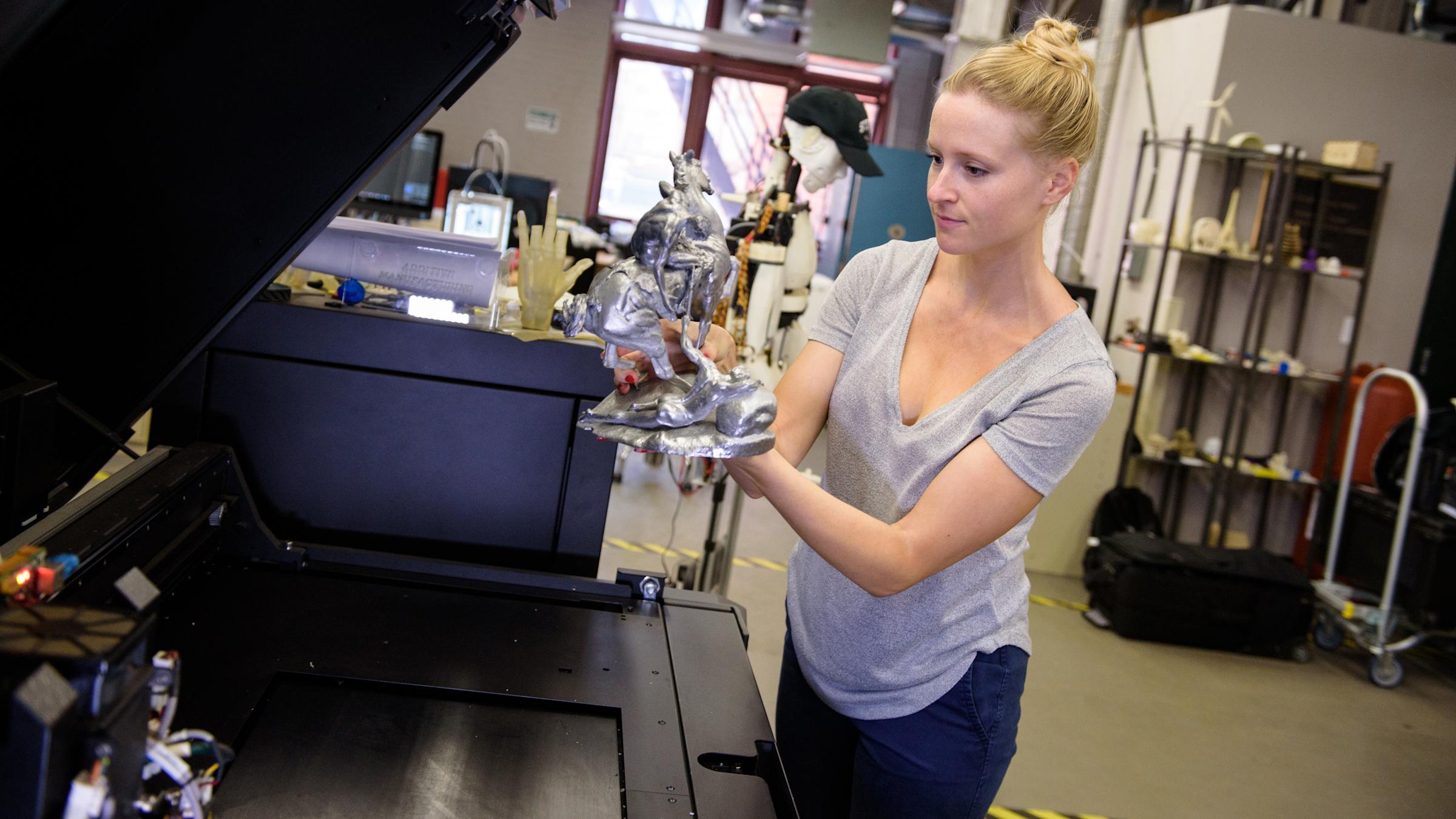 Female student holding a metallic statue