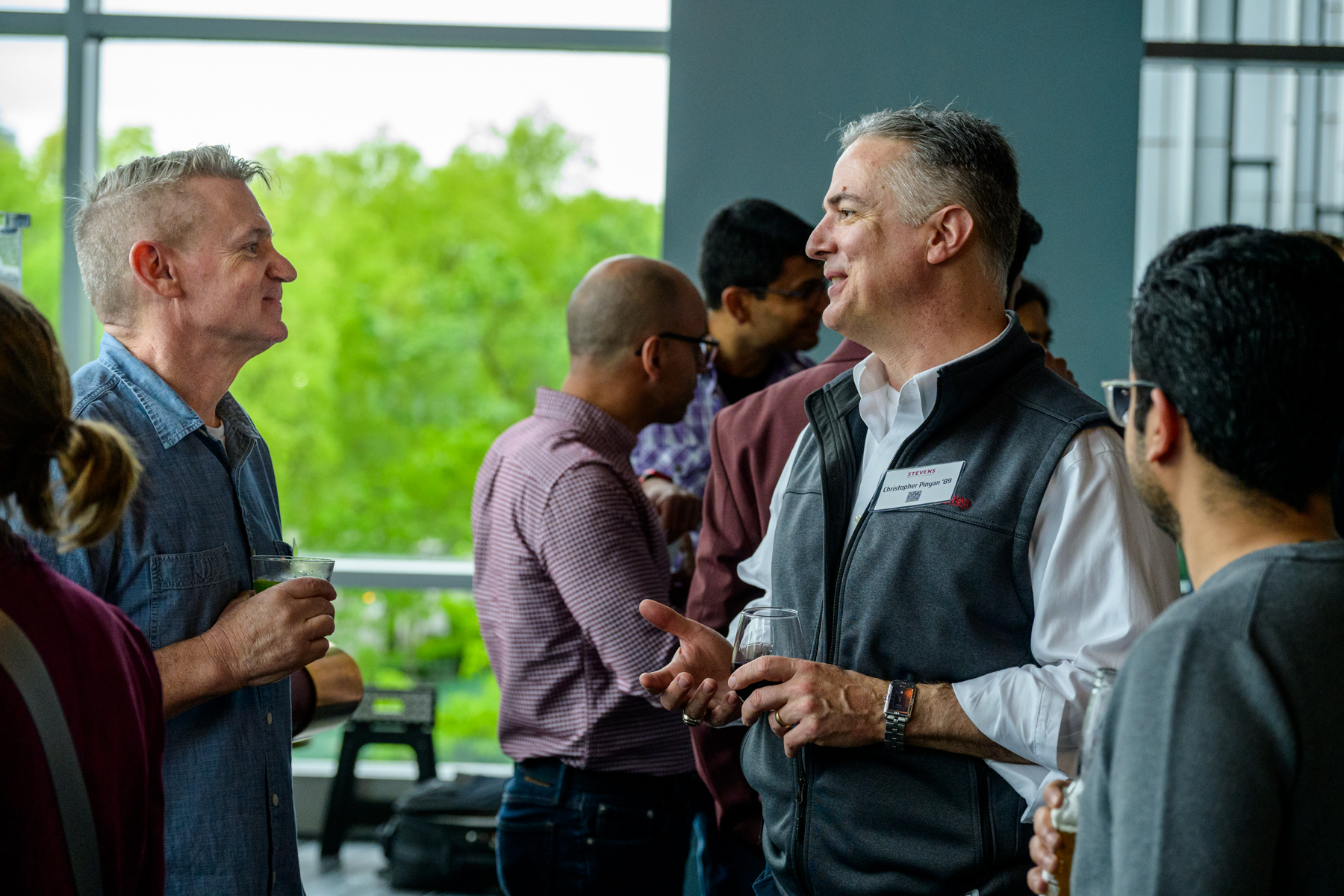 A group of alumni gather and chat with one another at a networking event