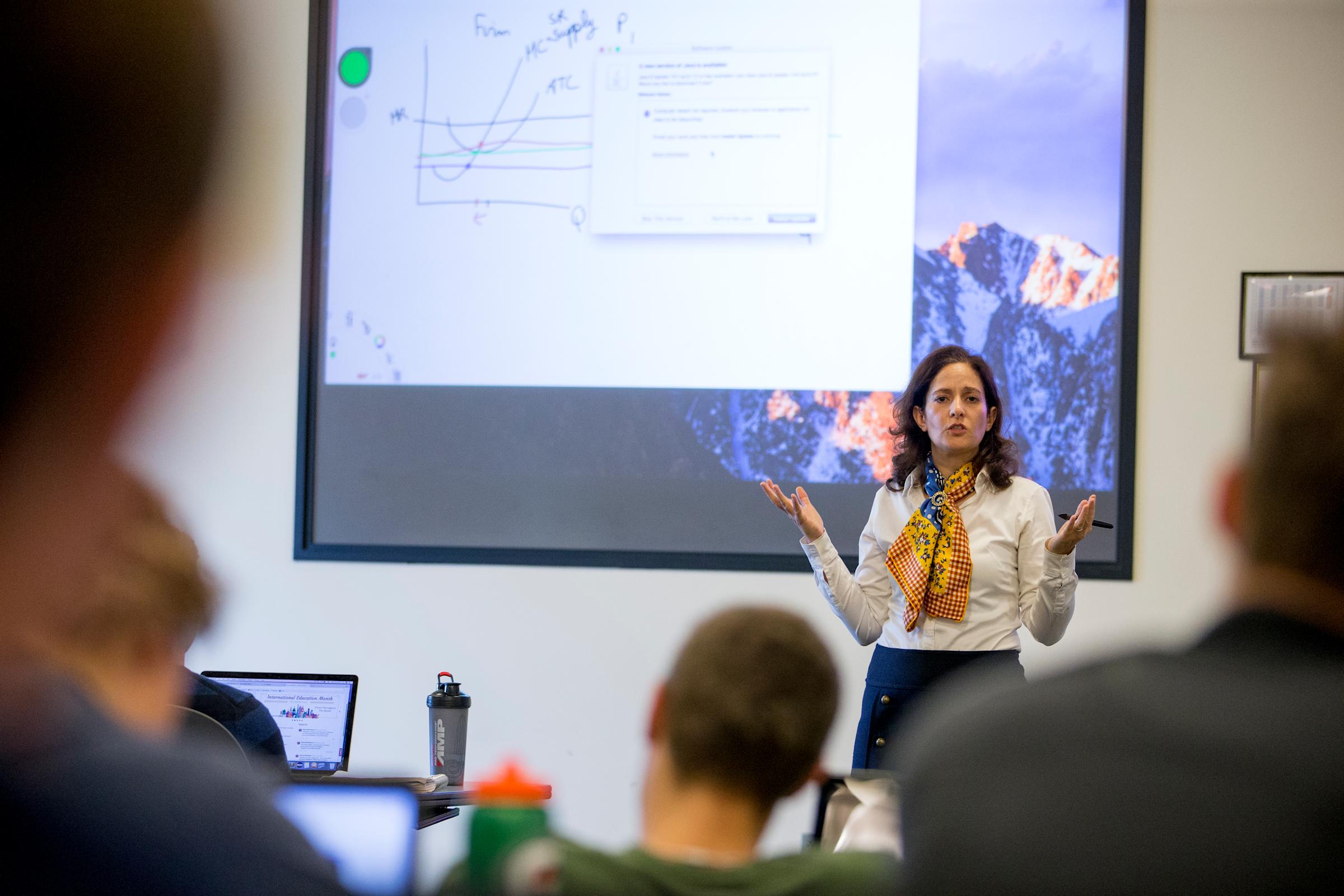 Joelle Saad-Lessler in front of a classroom teaching