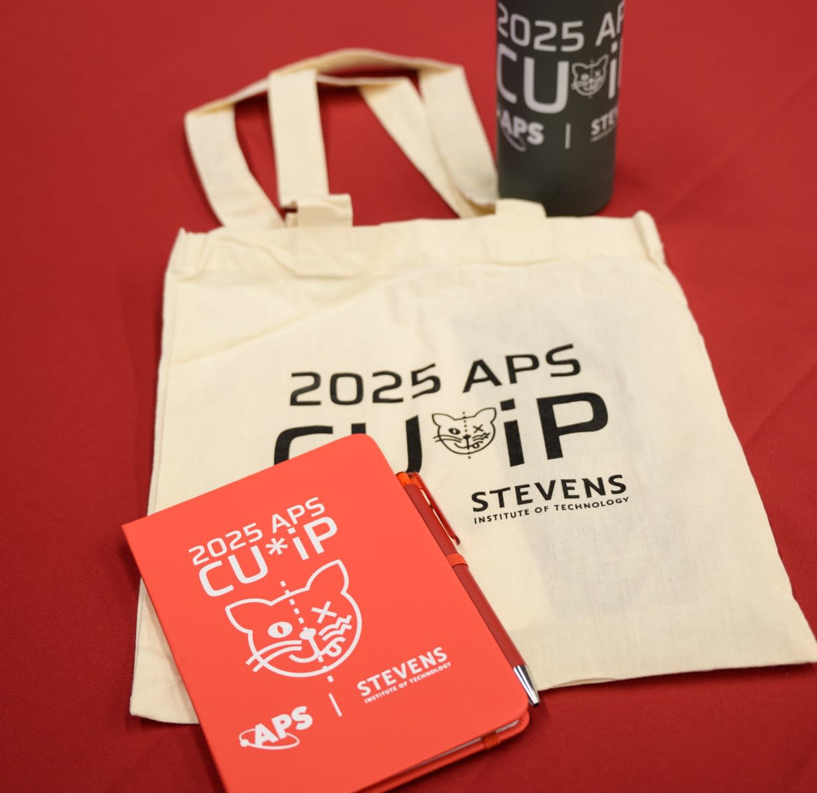 Custom designed merchandise including a thermos, tote bag and notebook for the 2025 CUWIP event at Stevens.